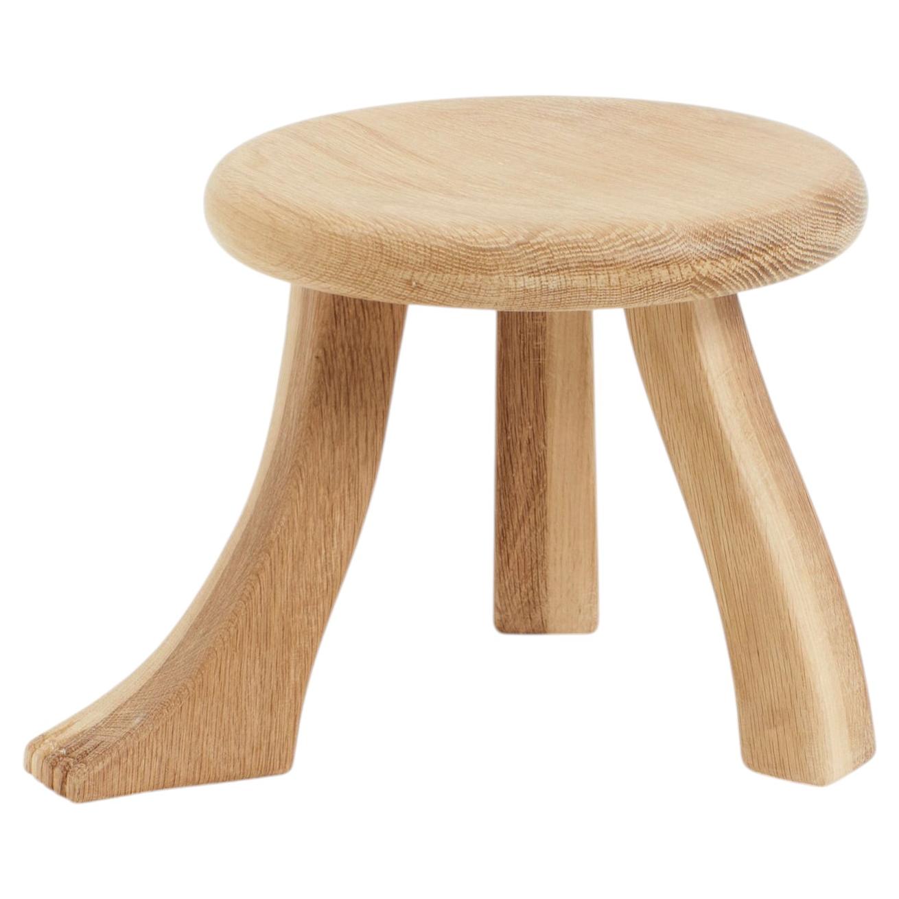 small hand-carved stool in solid oak with foot detail