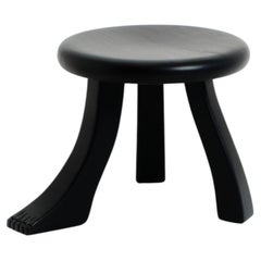 Taburete negro tallado a mano en madera maciza con detalle en las patas