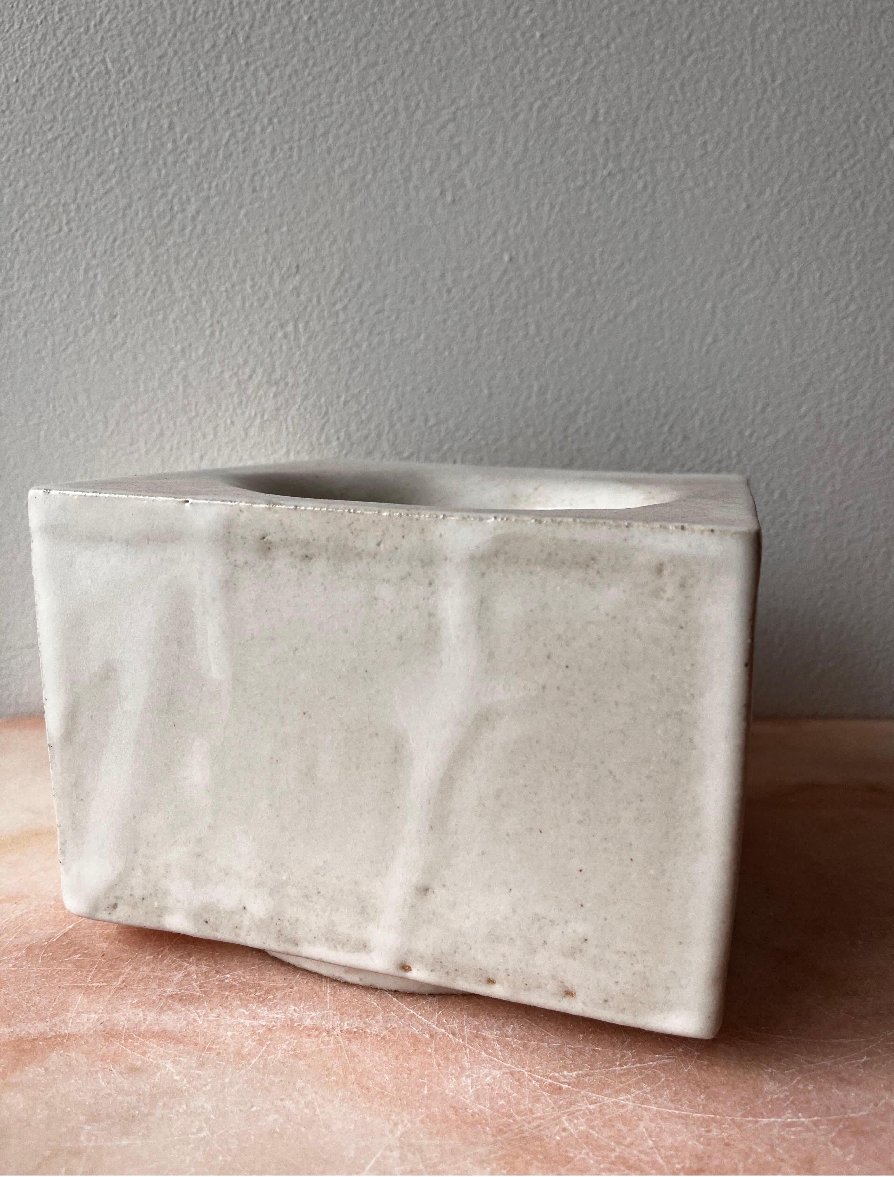 Diese handgefertigte Schale ist hohl, besteht aus sieben Steinzeugplatten und ist in mattem Weiß glasiert, wobei Tropfen und Überlappungen einbezogen sind und einzigartig sind. Es ist lebensmittelecht, obwohl es für dekorative Zwecke bestimmt ist.