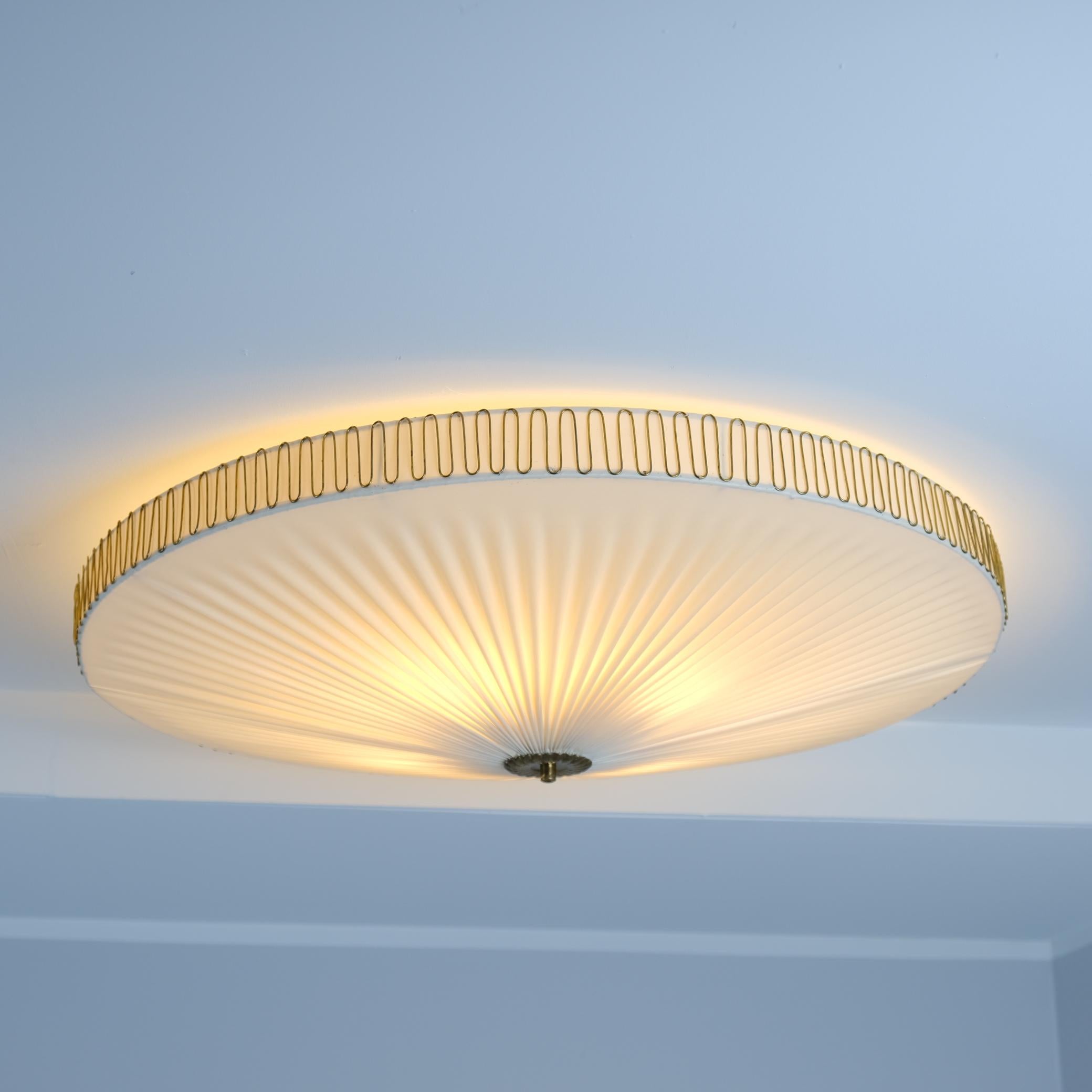 Questa elegante plafoniera a incasso Mid-Century Modern di Idman, realizzata negli anni '50, emana un fascino senza tempo grazie al suo bagliore morbido e diffuso e al suo design ben bilanciato. L'apparecchio rotondo presenta quattro lampadine
