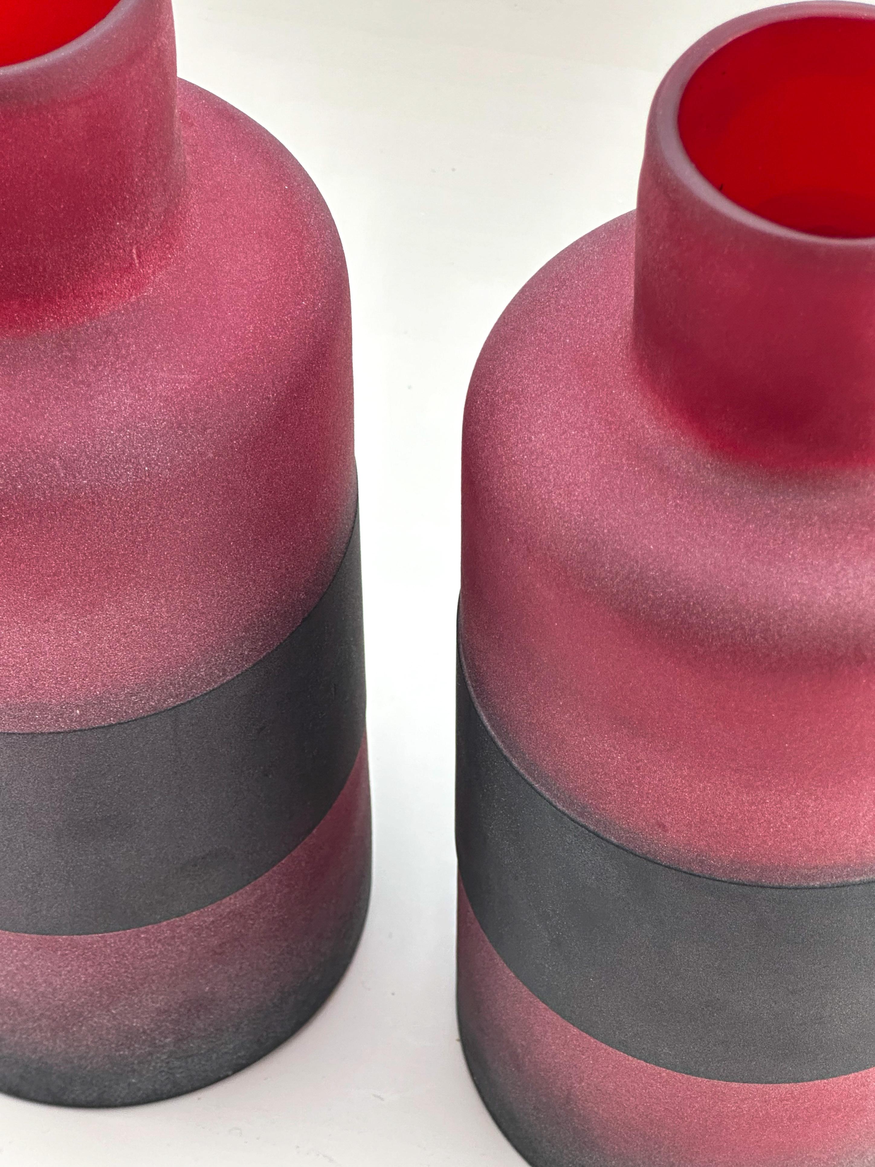 A pair of modern Murano glass bottles, attributed to Cenedese and dating to around 1990, showcasing the elegant balance of simplicity and craftsmanship for which Murano glassmakers are renowned. Formed with a tubular body and neck, each bottle is
