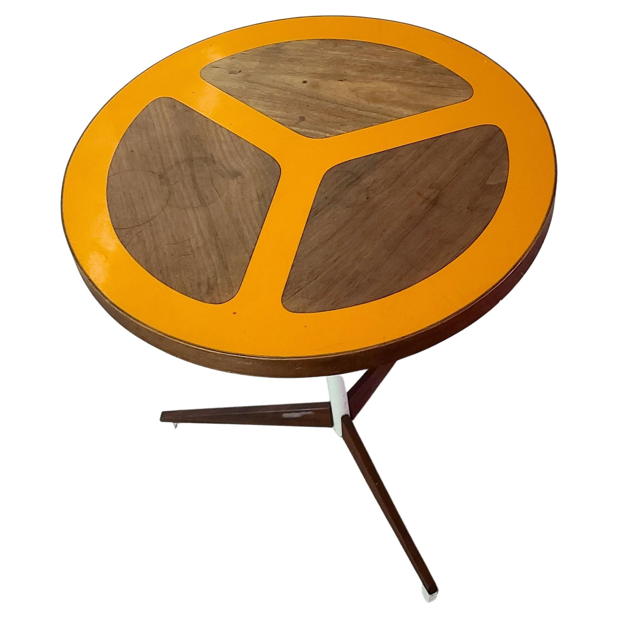 One Adjustable Table made by Peter Pepper Products. Designed by Don Savage and Howard McNab. Has an orange resin and walnut top in denoting a peace symbol. Shown in images as a unique table from an original set. This sale is for one table. Includes