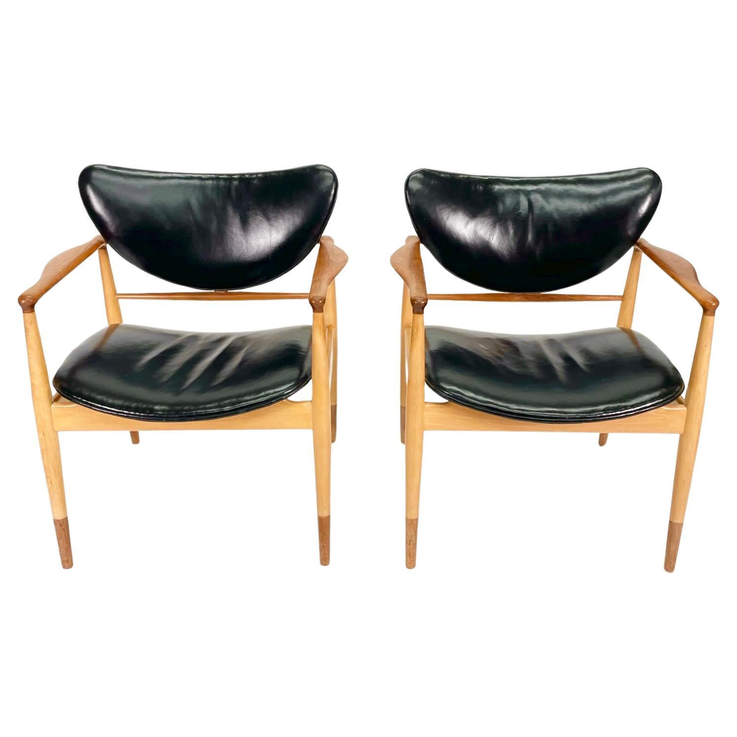 *Currently being restored*

This set of 2 Finn Juhl Model 48 Chairs by Baker feature solid teak and maple frames in two tones that are beautifully sculpted and incredibly comfortable with an equally attractive curved seat and back in original black