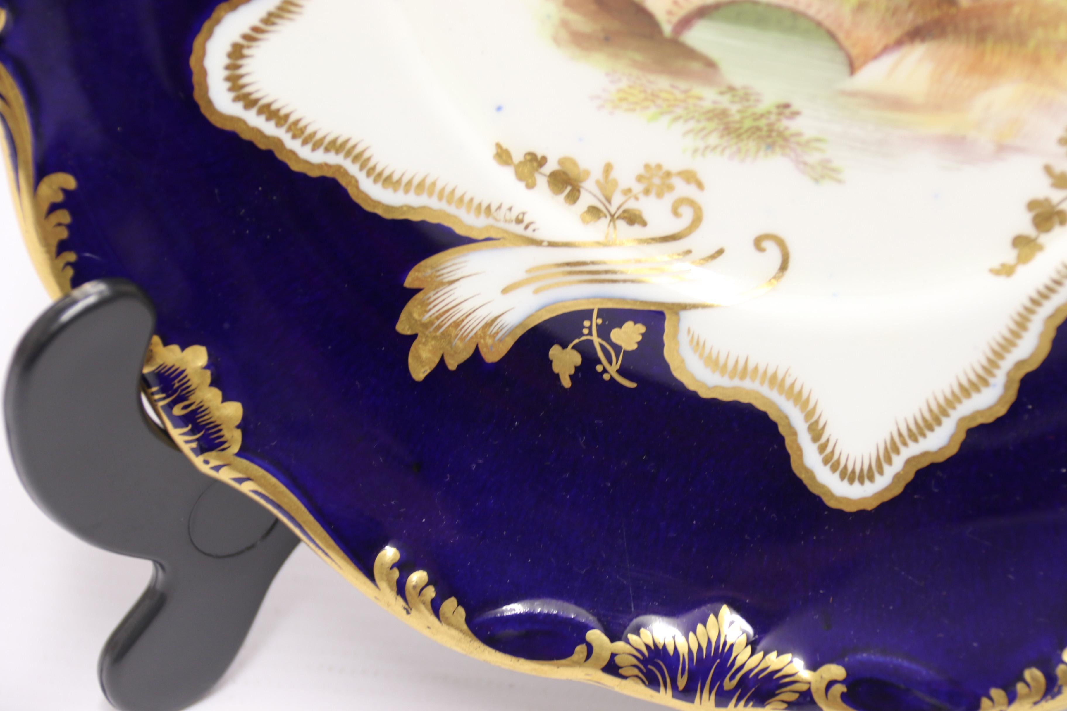 Diese feine, klassisch geformte, stilisierte Minton-Sahne-Terrine steht auf einem ausgestellten Fuß mit einem fein ausgearbeiteten Stiel. Der Hauptkörper hat ein breites, flaches Design mit einem Paar verflochtener Griffe auf jeder Seite und einem