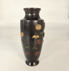 A Japanese Meiji period bronze vase decorated in high relief foliage and a bird
