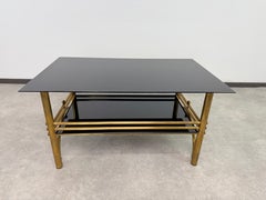 Mesa de centro posmoderna de dos niveles, con estructura de latón y cristal negro, estilo Hollywood Regency