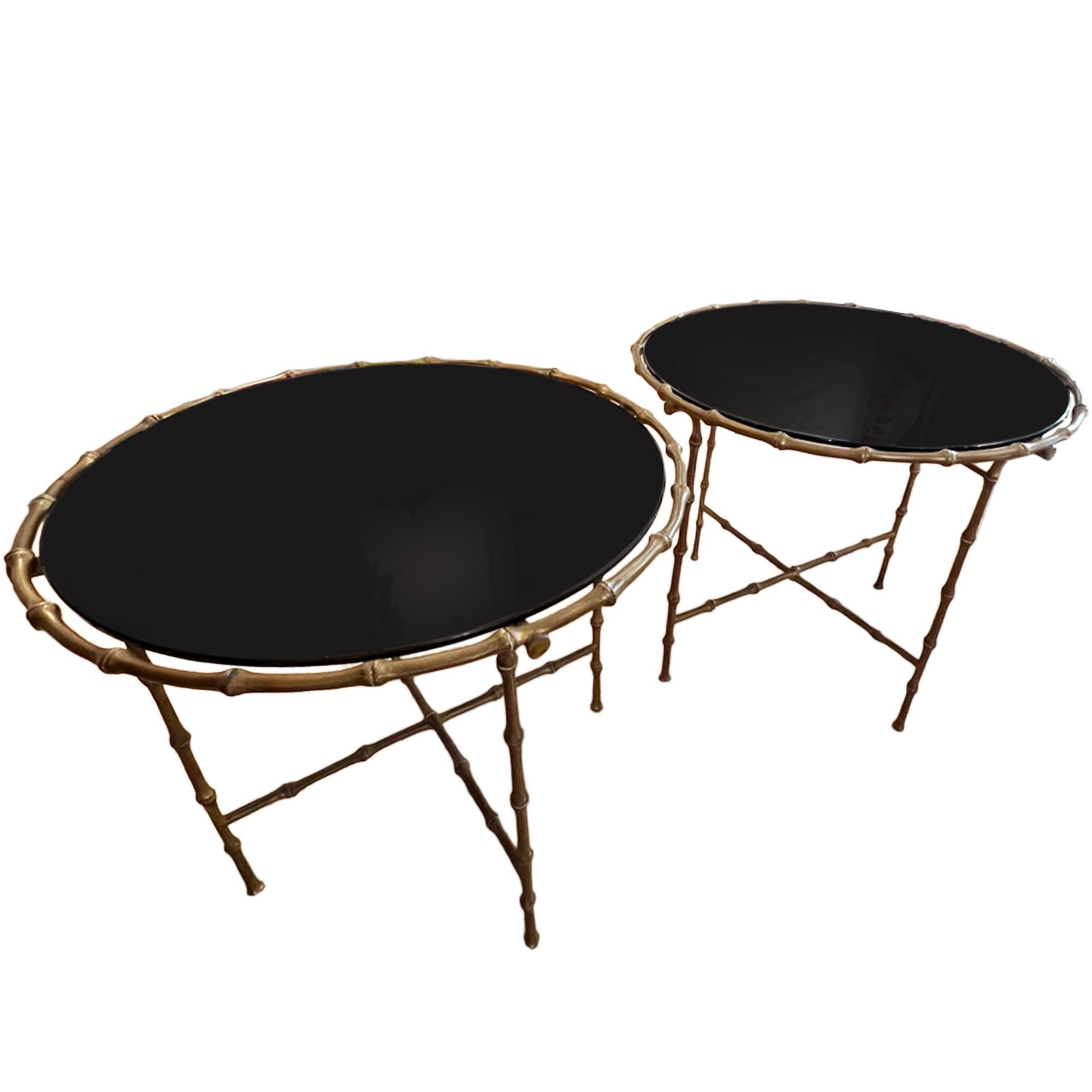 This stylish pair of brass faux bamboo and black glass round side tables were made in France in the 1960s.  Crafted in the style of Maison Baguès.

Very nice casting of the brass frames - please take a look at all our pictures to see the detail on