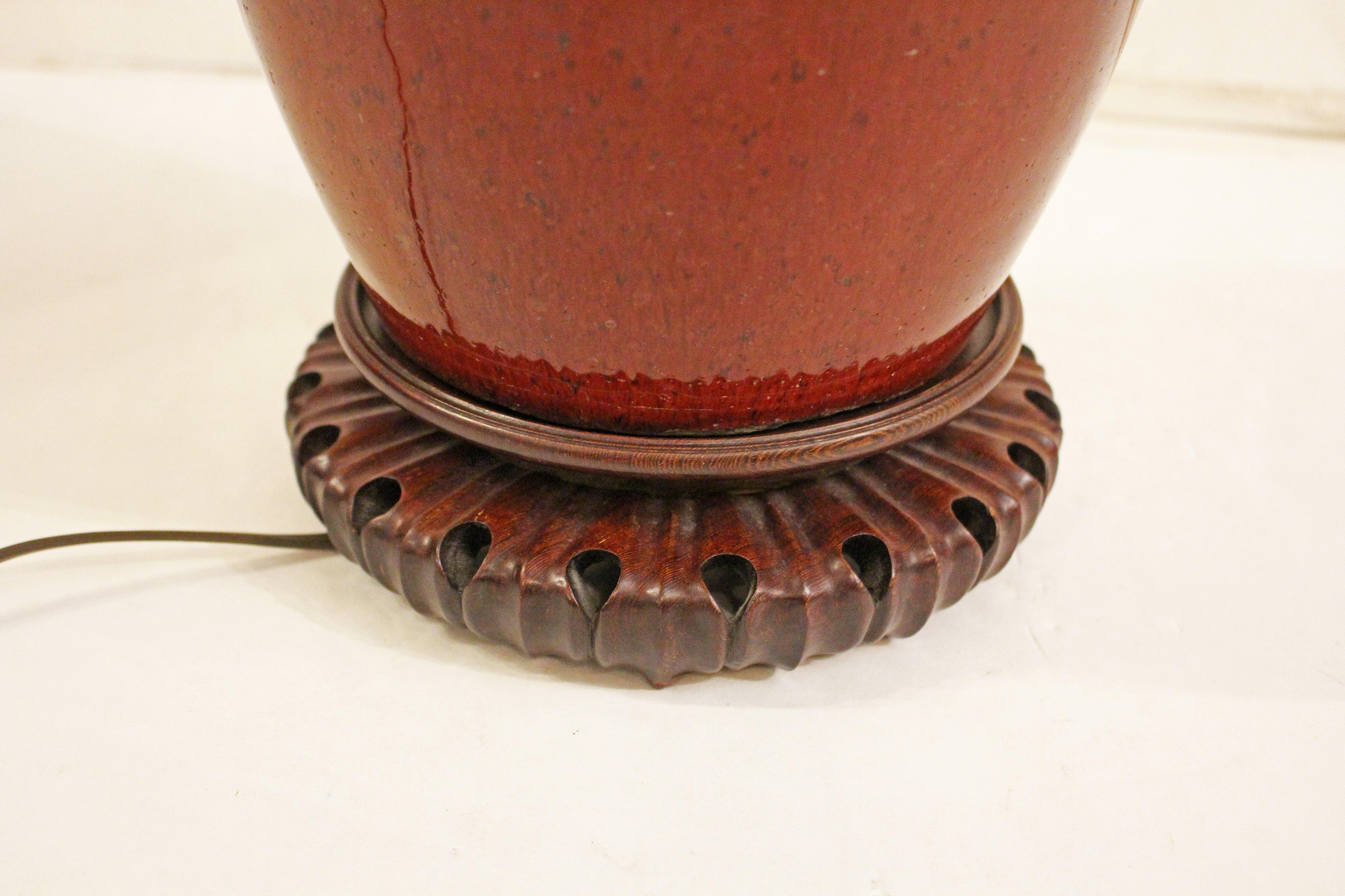Jarre en porcelaine chinoise vernissée Sang de Boeuf du milieu du 19e siècle, montée en lampe. Base en bois de rose finement sculpté. Bocal : 11.25