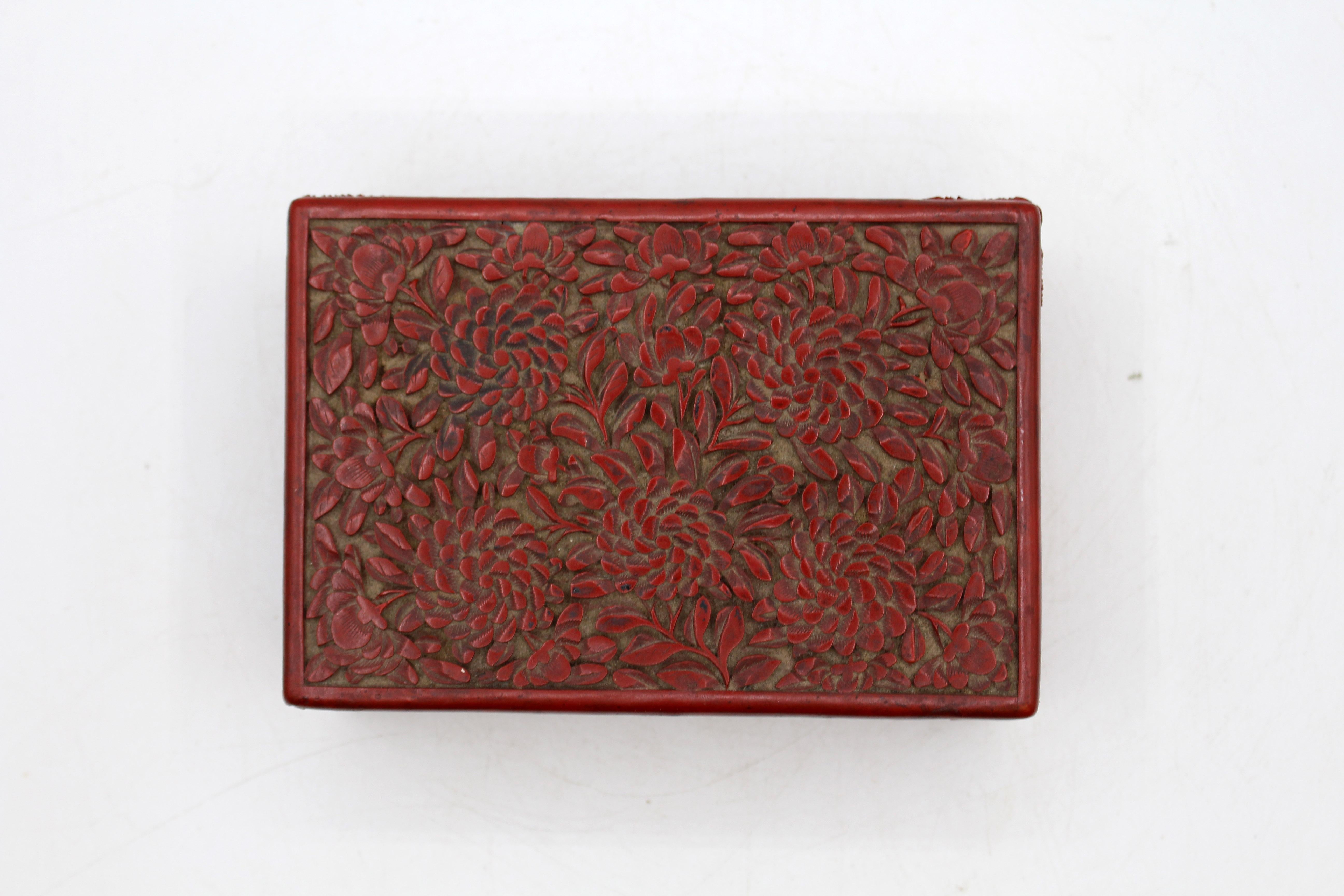 Caja china de laca tallada en cinabrio de finales del siglo XIX. La parte superior, un remolino de crisantemos; los lados, una serie de cuadrados concéntricos o rombos según la perspectiva del conjunto. Mellas muy leves en la parte inferior. La