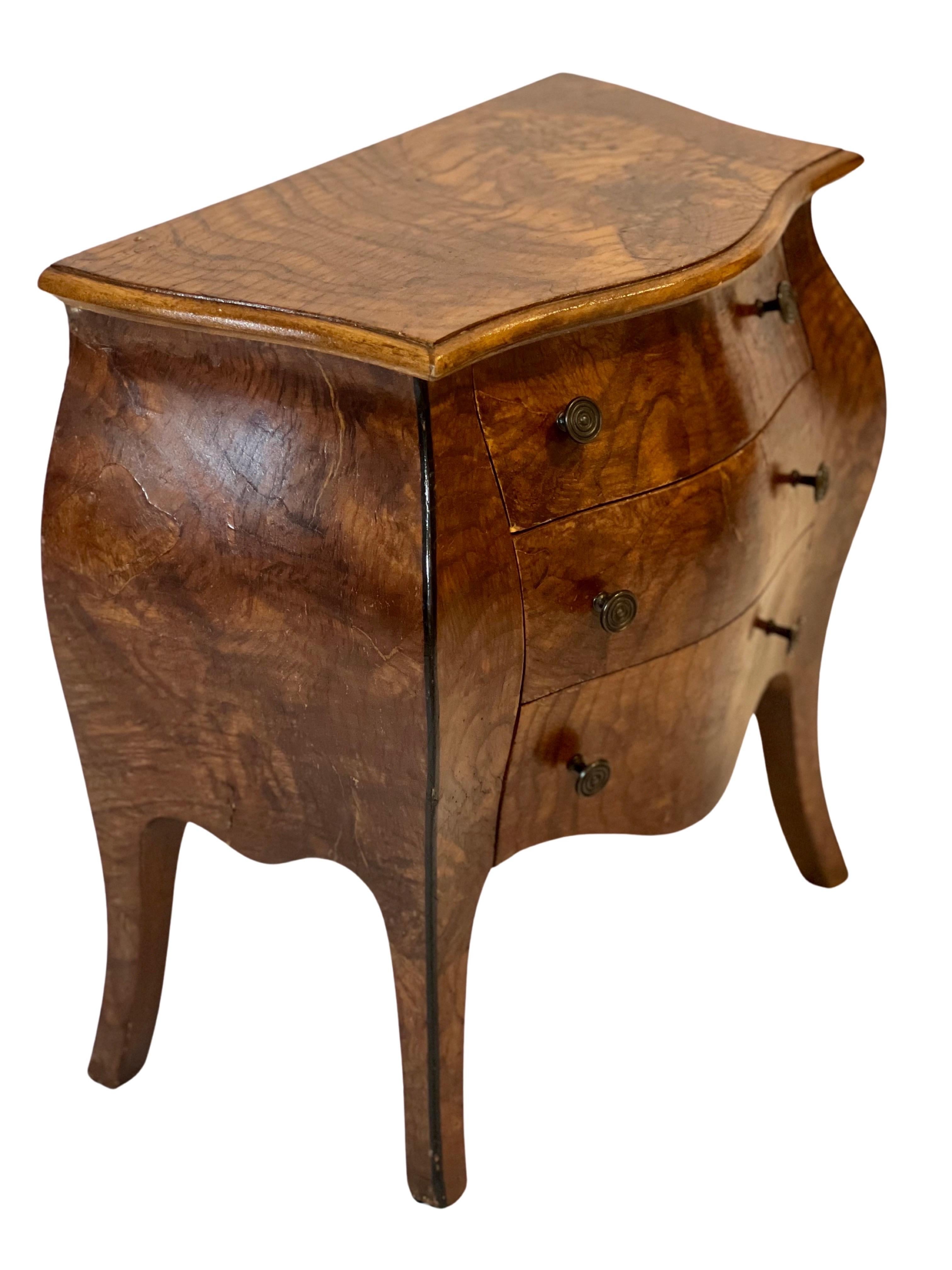 Vintage miniature Bombay chest, made in Italy, c. 1950's.

Charming Louis XV style commode in beautiful olive wood and walnut burl. It features three dovetailed drawers with bronze finish concentric pulls and fleur-de-lis liner. 

An elegant and