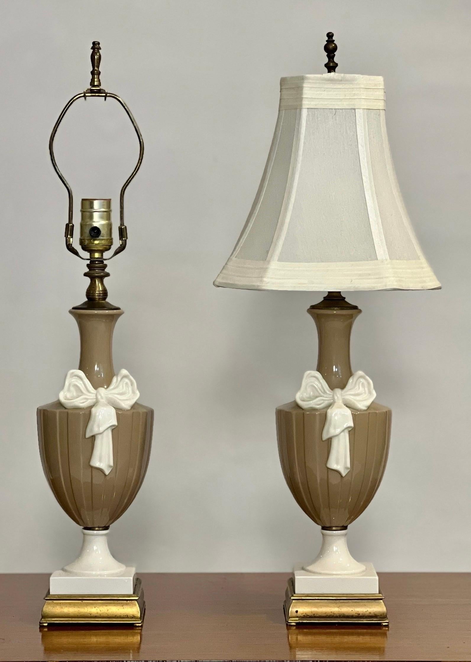 Pair of Lenox attributed Neoclassical style urn form porcelain lamps by Dav Art, NY.

Charming, petite lamps in a soothing modernist color scheme of taupe and creamy white set upon square brass bases with an intricately detailed bow draping down the