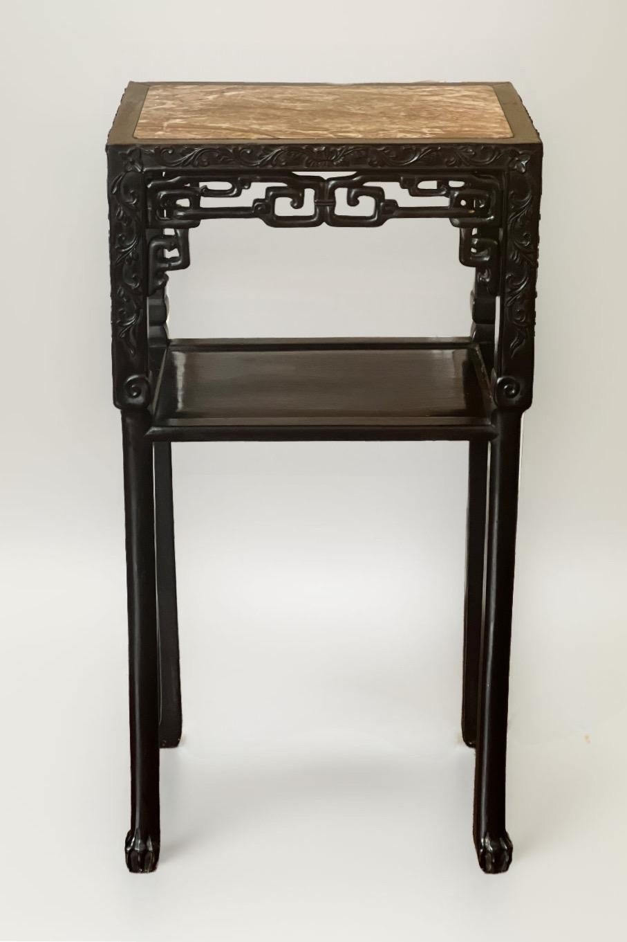 19th century Qing dynasty carved hardwood pedestal table or plant stand with inset rouge marble top.

Rectangular black lacquered pedestal table with a carved and pierced frieze with a relief scrolling foliate design framing the reticulated