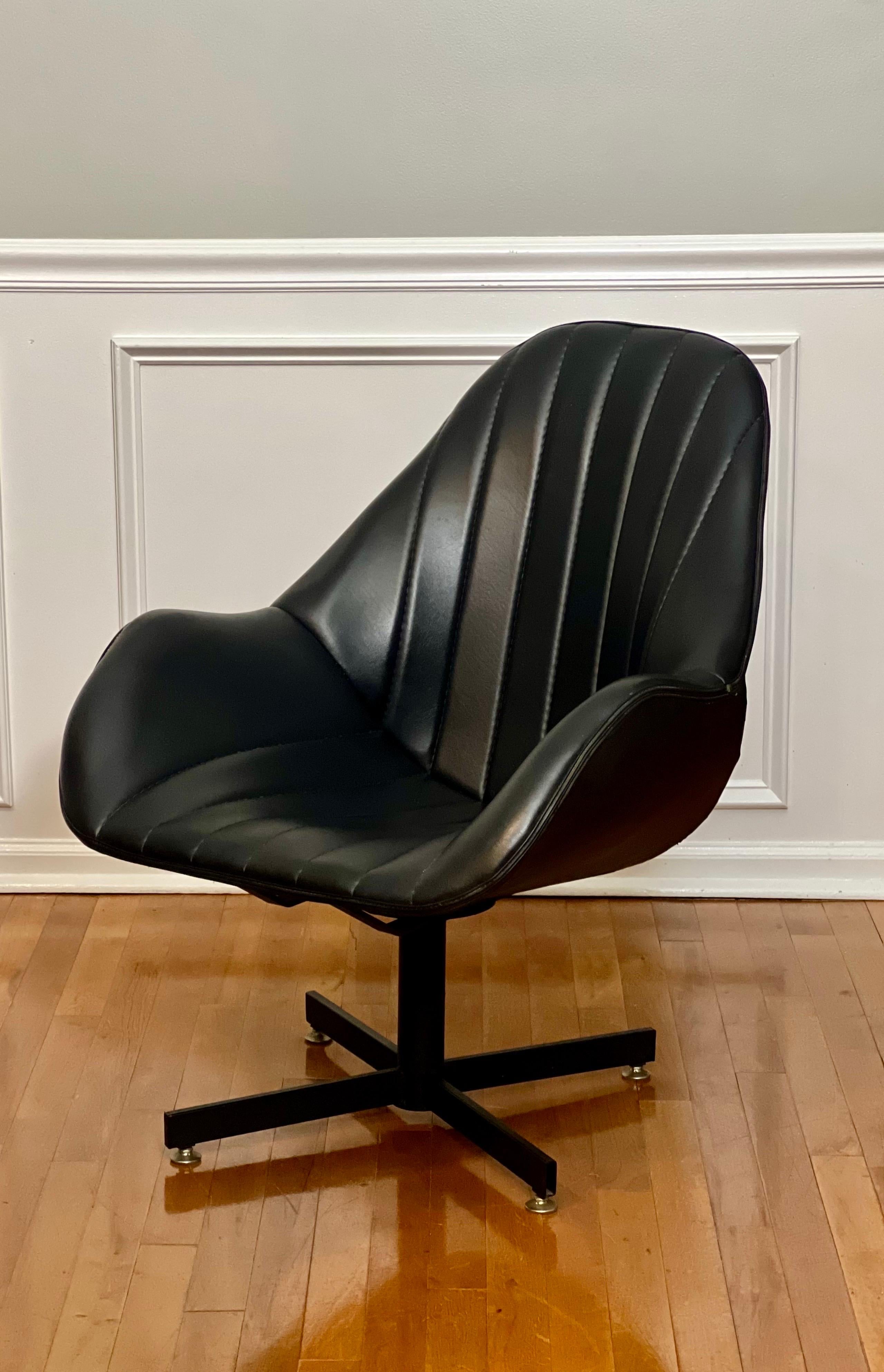 Vintage space age 1970s faux leather swivel bucket lounge chair on a black metal base. Well made and comfortable with very little use noted. It swivels smoothly and channel tufting provides lots of comfort. It is in very good, sturdy vintage