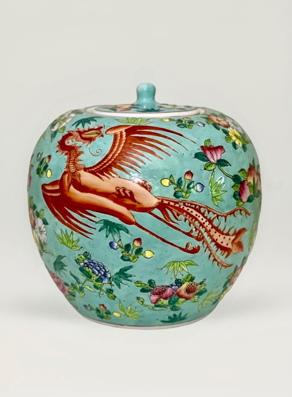 Vibrant vintage Chinese hand-painted, ovoid form porcelain lidded ginger jar, circa 1960-70s. The jar displays prominent, bright coral phoenix birds against a turquoise background surrounded by peach blossoms, pomegranates and peonies. A beautiful