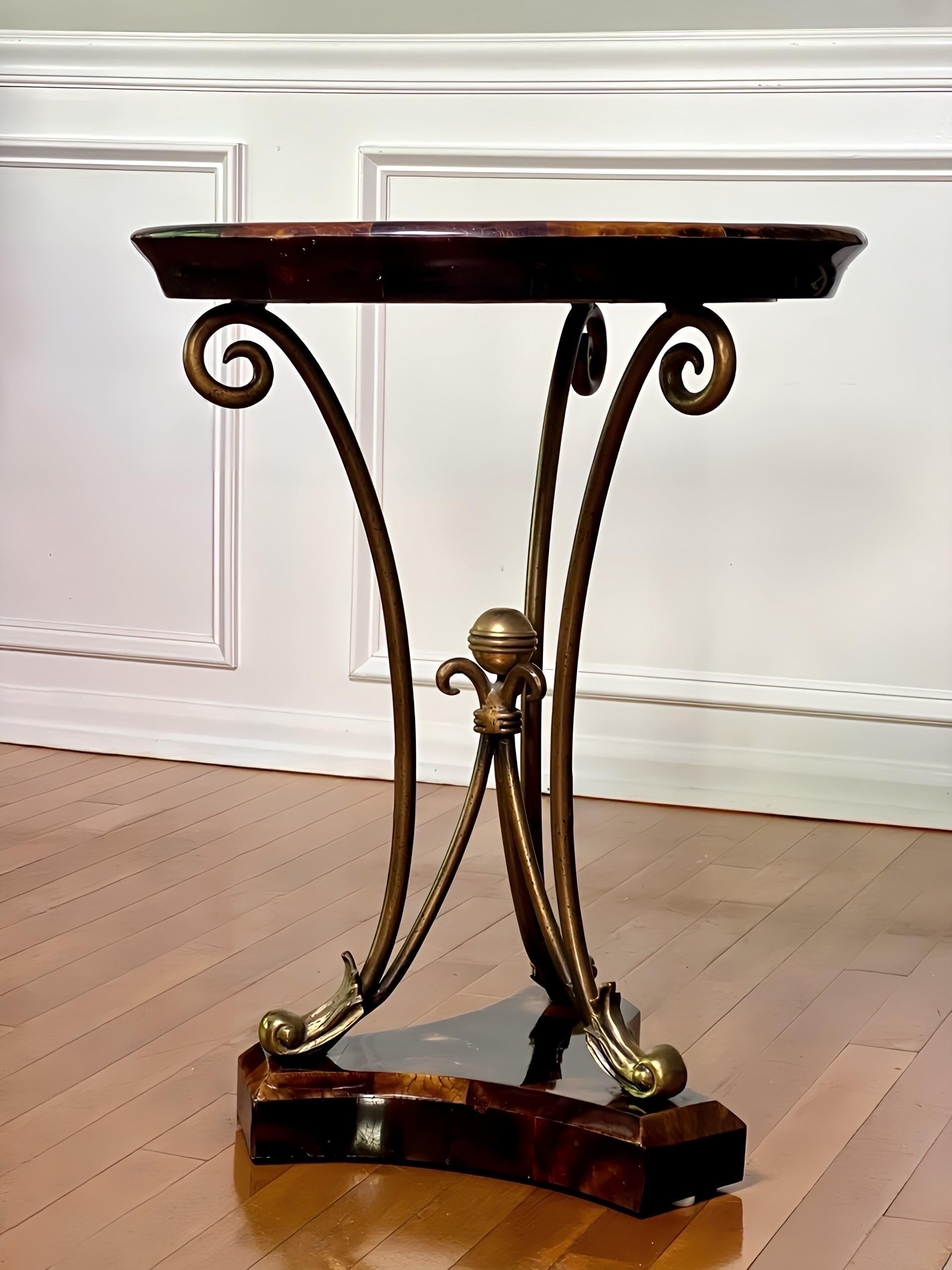 Elegant 1970s Maitland Smith tessellated side or occasional table with crackled, polished horn veneer.  A round, affixed tray style top rests on bronzed metal tripod scroll legs with embellished feet and a central ball finial, raised on a beveled