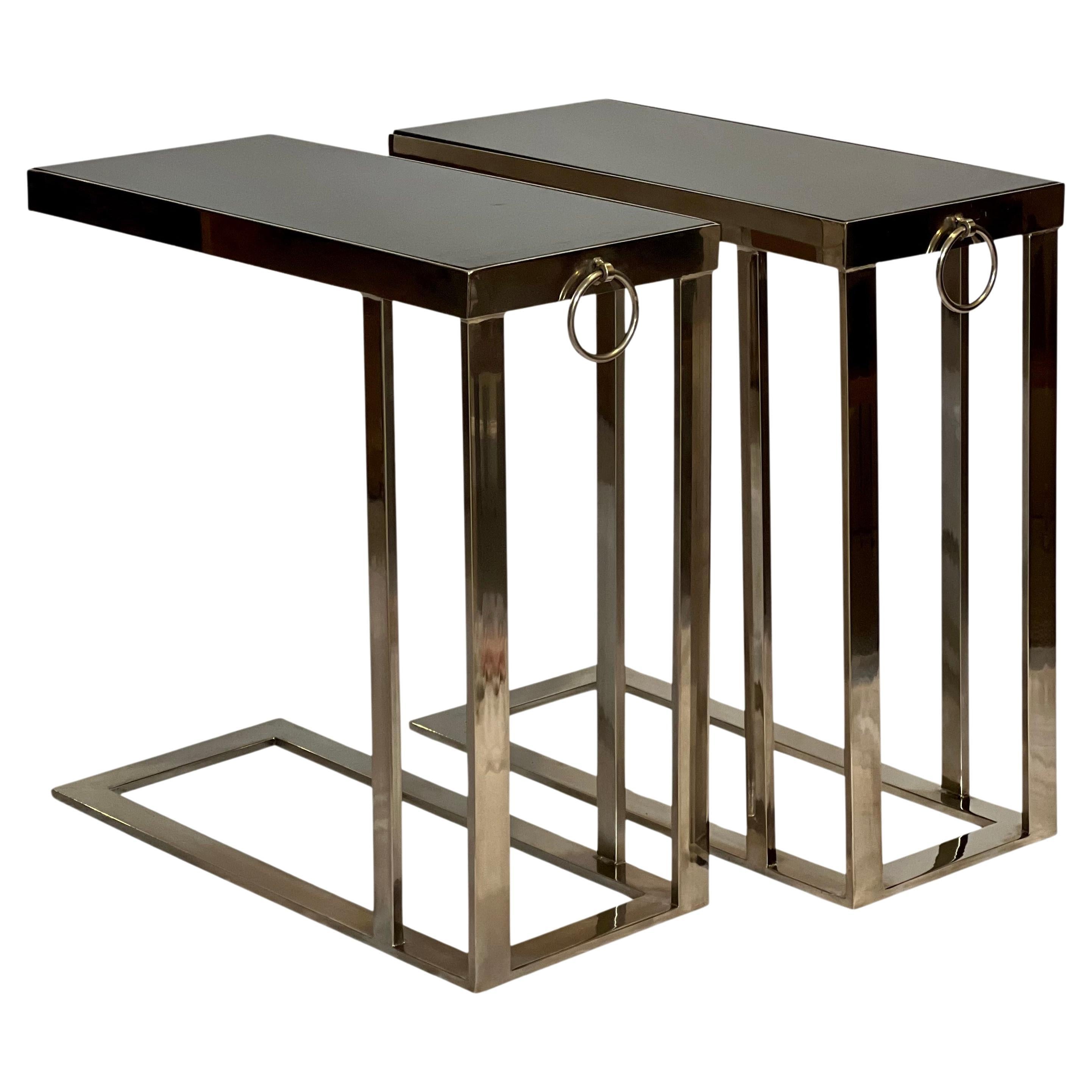 Sleek flat bar chromed steel cantilever side tables with black marble tops and bullnose ring detail. The pair offers a slim silhouette with a polished and sturdy flat bar frame. 

Practical and beautiful, the cantilever style allows you to slide the