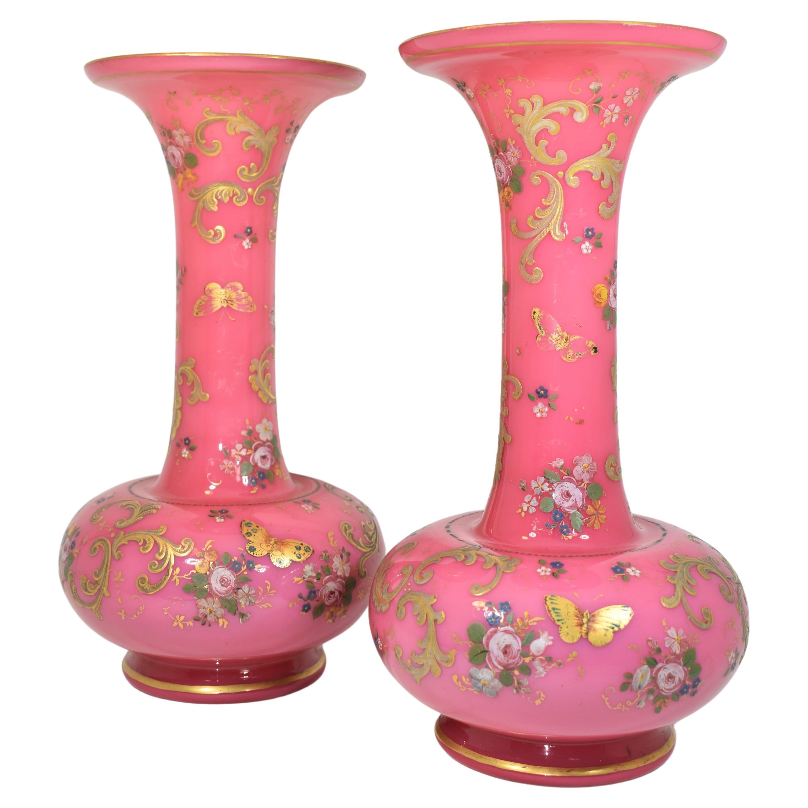 An exeptional pair of vases made of two-layers enamelled opaline glass, opaque white on the inside and pink on the outside, the circular bodies richly hand-painted all around with gilded enamel decoration, the high quality enamelling features