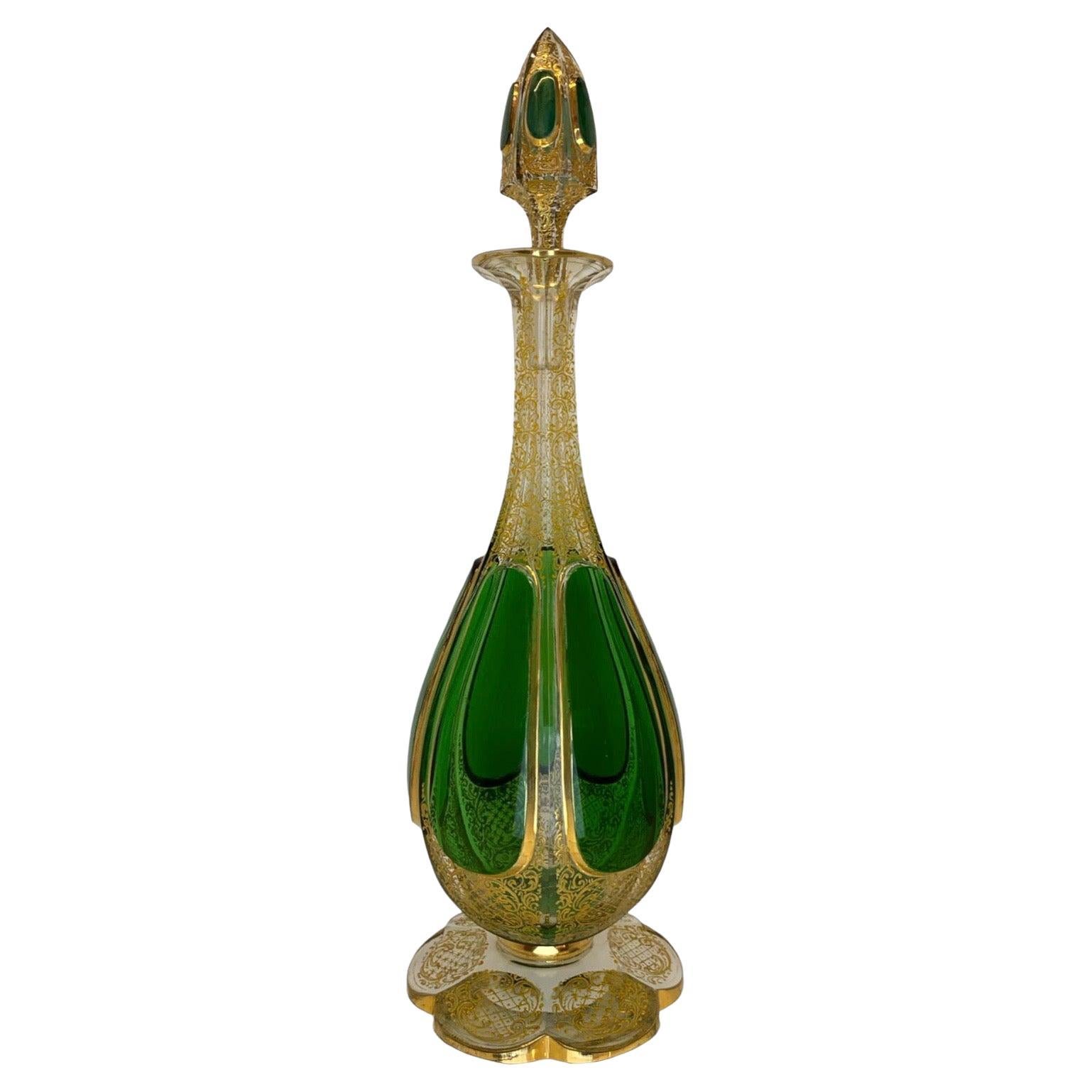 A Large Bohemian green cut to clear glass decanter with stopper

Cased Glass with Emerald Green Cabochons Panels

Green Cut to Clear in Three Layer Cased Glass.

Decorated with Composite Gold Enamel Scroll Work

Moser, 19th Century

40 cm