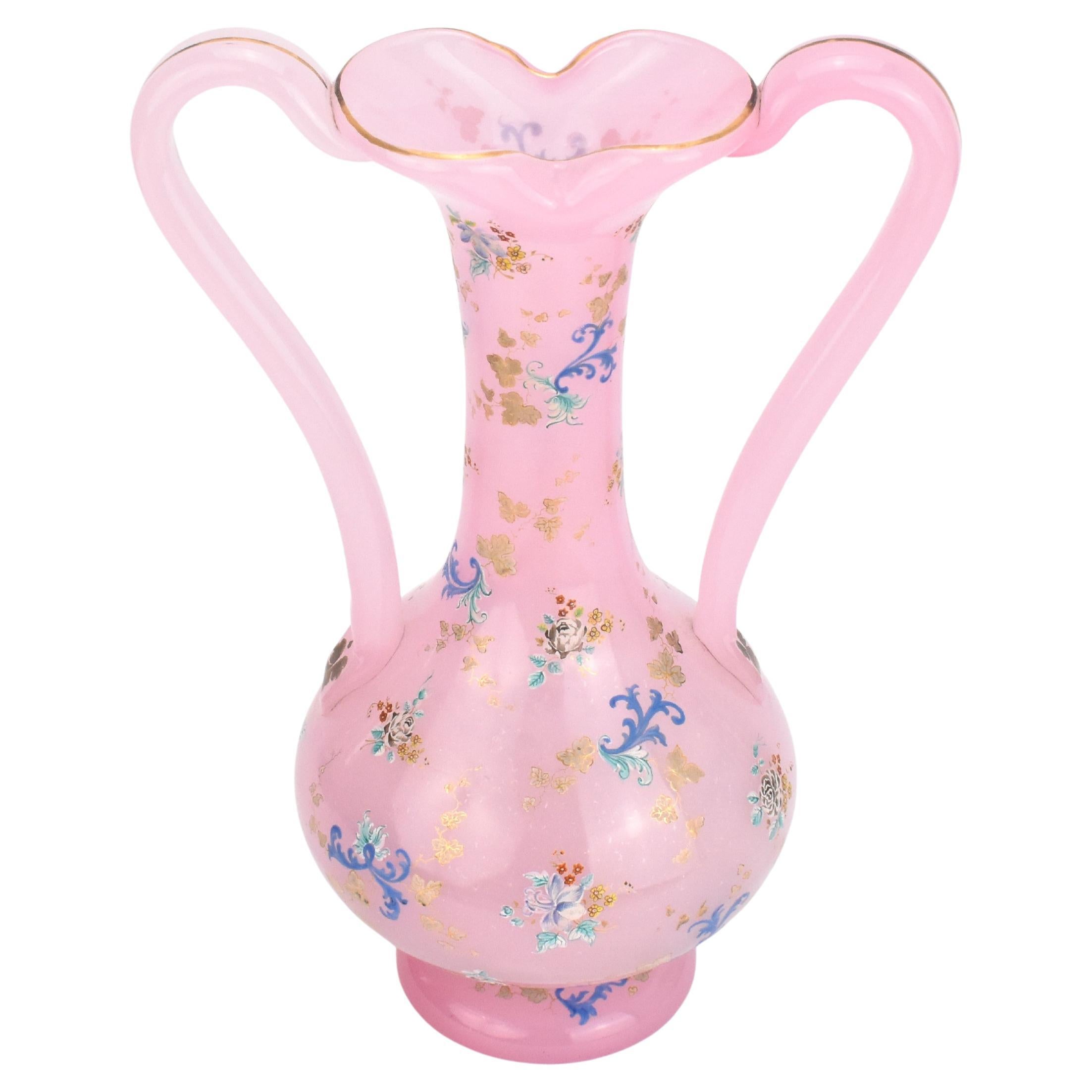 Exceptionnel vase à deux anses en verre albâtre opalin rose de Moser

Le corps circulaire est richement décoré d'émaux colorés représentant des fleurs, des vignes et des rinceaux.

décor émaillé sur la base, le vase à bord ondulé et doré et les