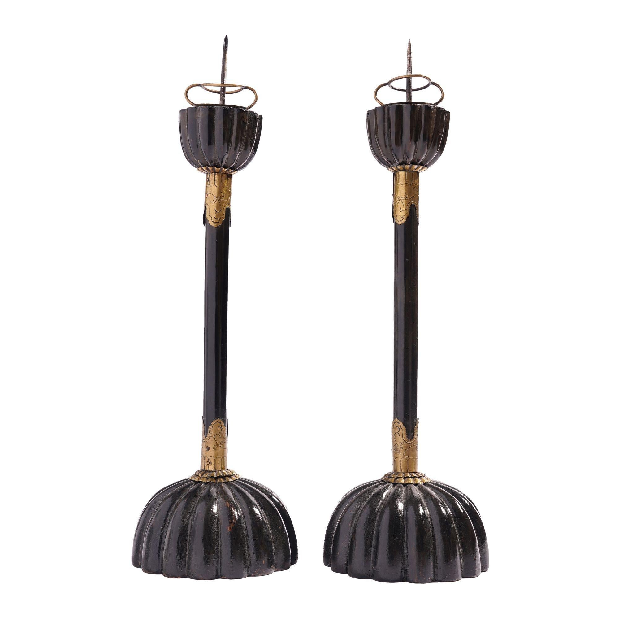 Pair of Japanese black lacquered hardwood altar candlesticks. The sticks feature a melon carved base, lacquered wood rod with engraved brass fittings, and a melon carved candle cup with brass pricket.

Japan, 19th century.

Dimensions: 4-5/8” D x
