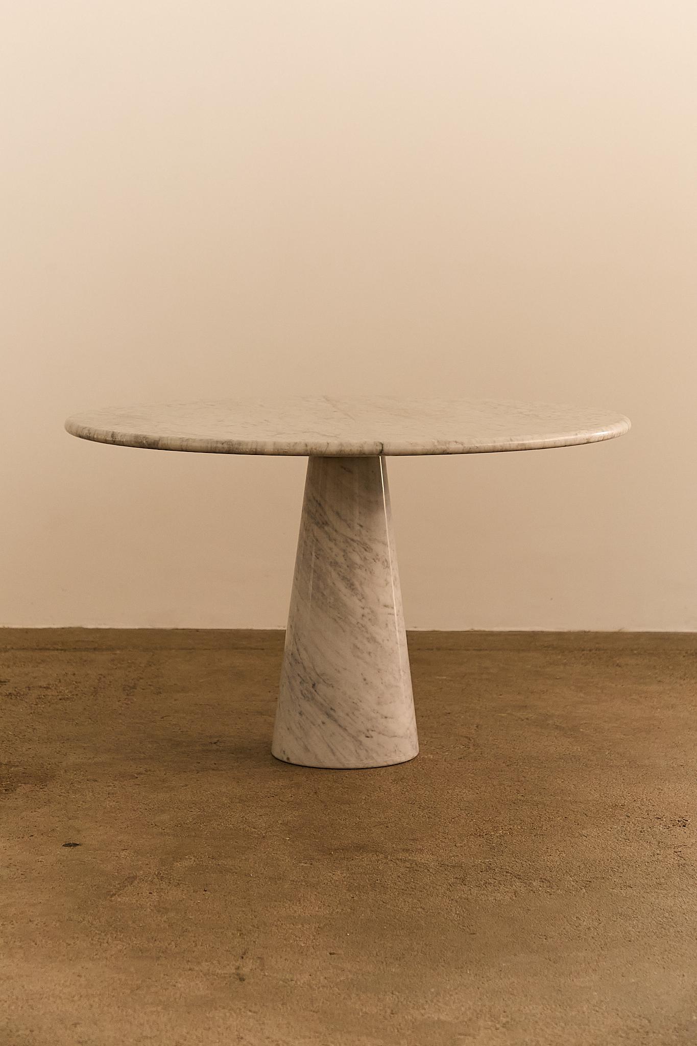 Sculptural dining or center table crafted entirely from Italian Carrara marble. The design features a circular top resting on a conical base, a hallmark of Angelo Mangiarotti’s architectural aesthetic—balancing elegance, mass, and material integrity