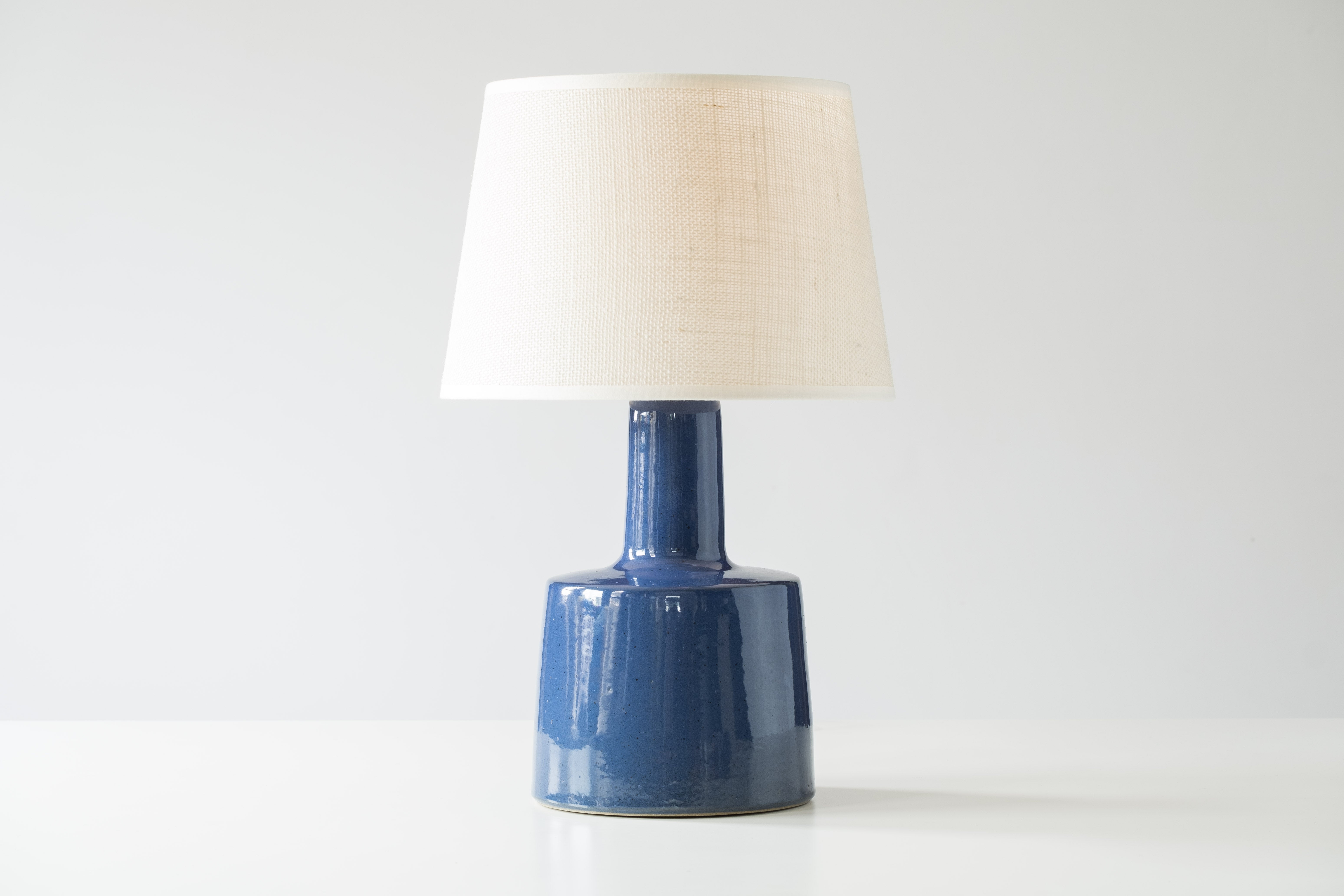What is it?
—
Another gem from the masters of mid century lightning – Gordon and Jane Martz.

This signed Martz model 105 lamp comes in a glossy dark sapphire blue glaze with tiny flecks and specks of darker colors.

This is a beautiful piece that