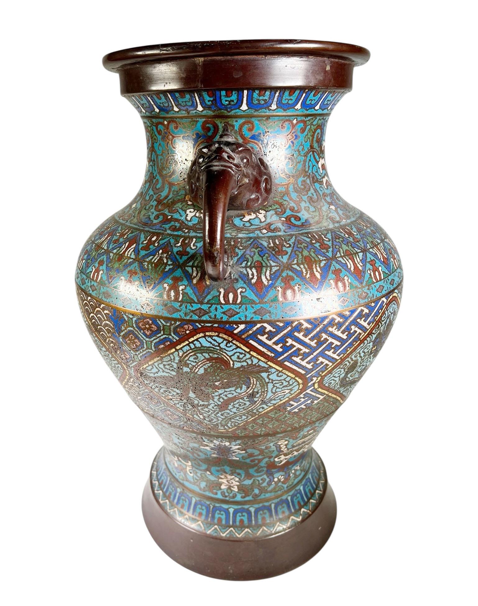 Un'imponente urna cinese cloisonné del XIX secolo, risalente al 1870 circa, caratterizzata da superfici riccamente smaltate e da audaci manici a forma di bestia in bronzo. Il corpo è splendidamente decorato con la tradizionale tecnica cloisonné, con