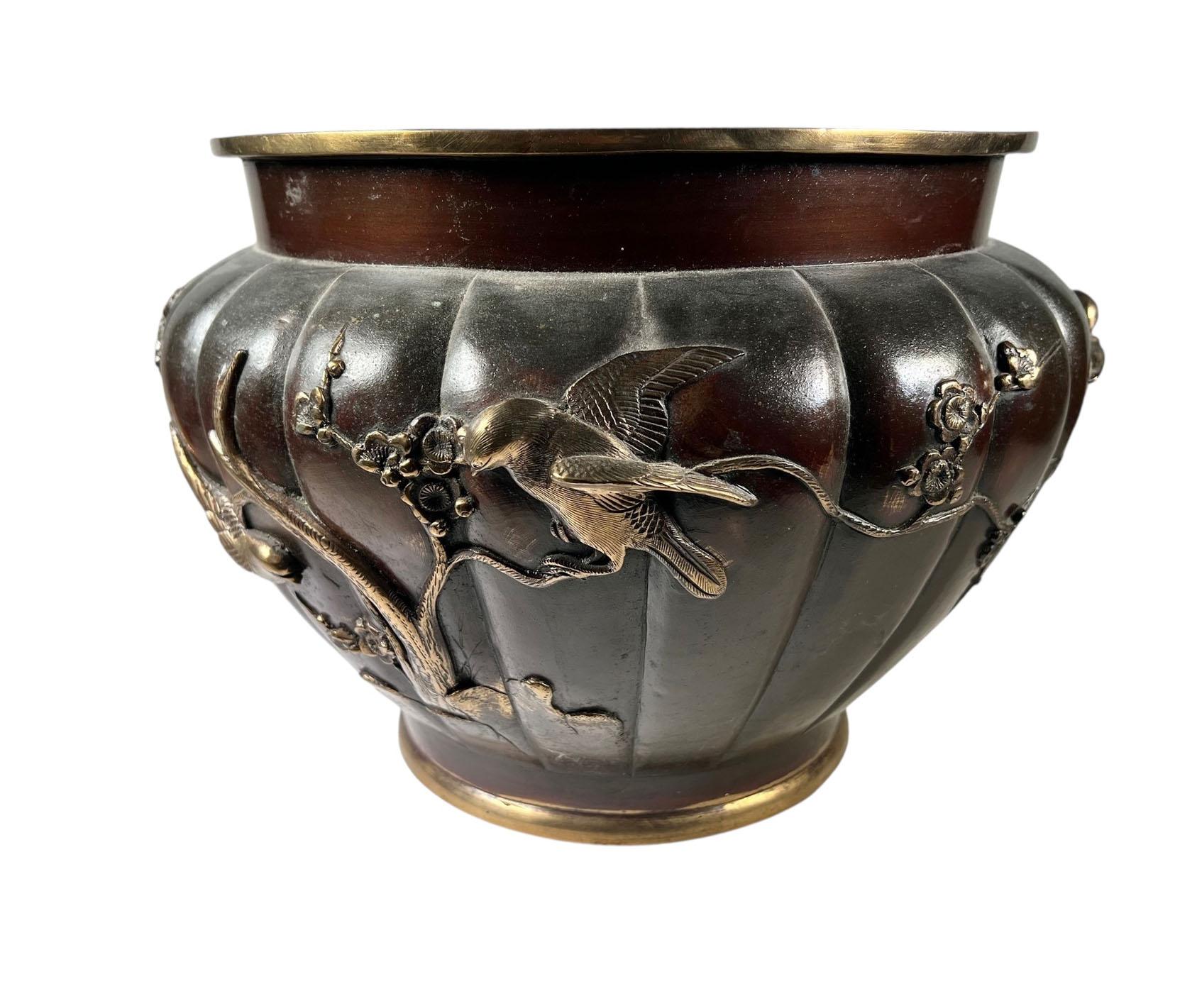 Uno squisito jardinière in bronzo cinese della metà del XIX secolo, magistralmente fuso con un corpo profondamente smerlato e ornato in alto rilievo con eleganti uccelli appollaiati tra rami fioriti. La scena si avvolge con grazia intorno al vaso,