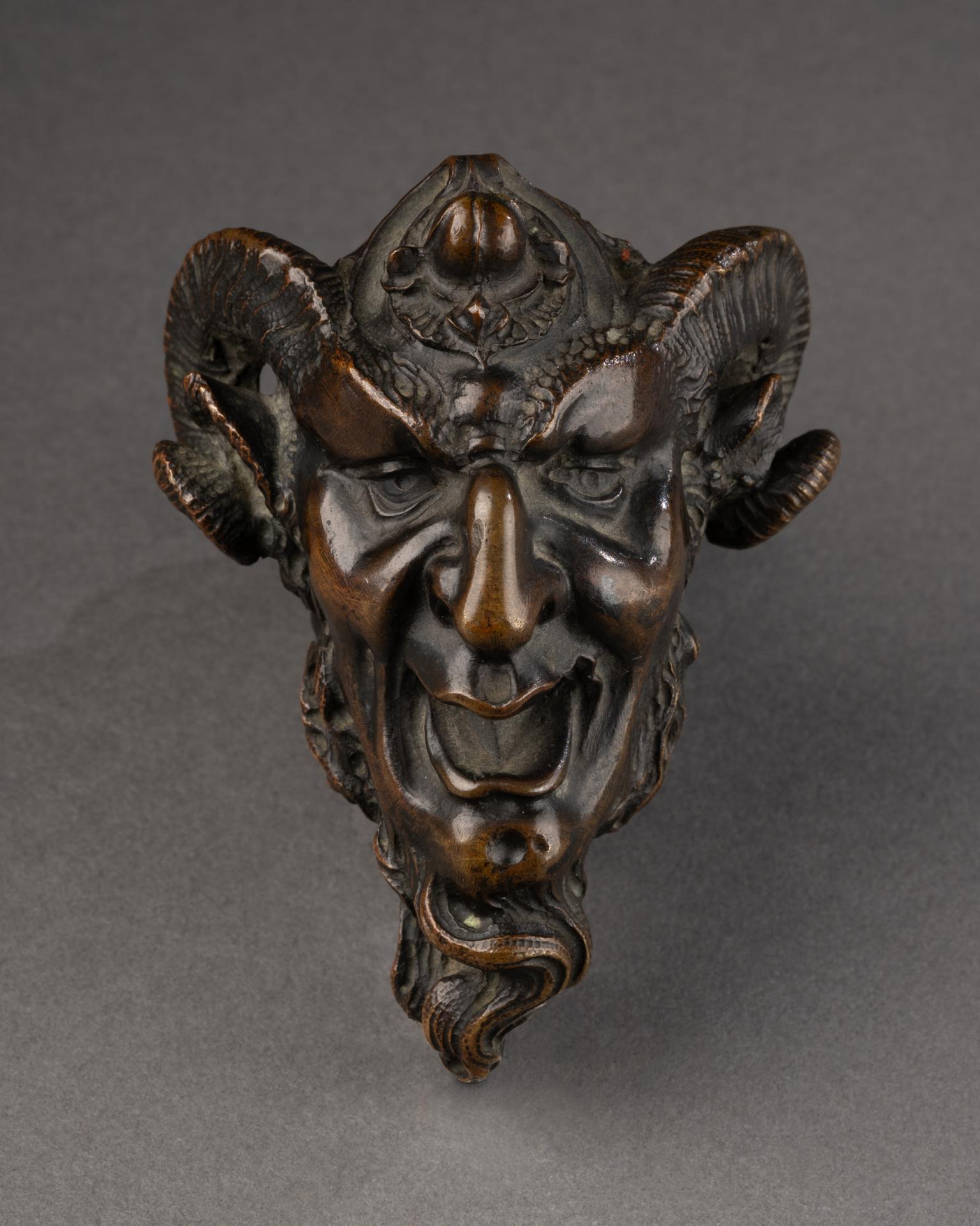 Handle in the Shape of a Devil’s Head 
Patinated bronze
 France, 19th century
10 x 7,5 x 9 cm

This unusual bronze handle takes the expressive form of a devil’s head, with exaggerated, grimacing features. The vivid modeling of the face—with its