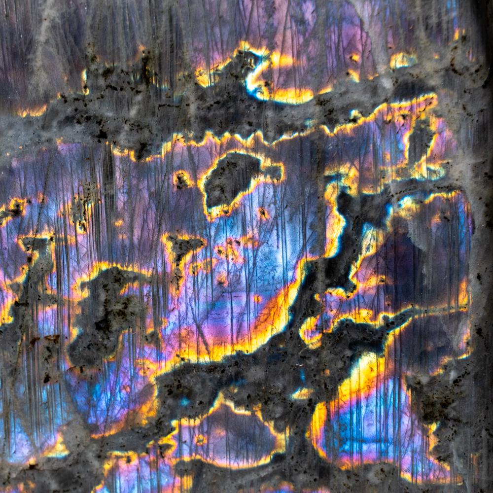 Labradorite di prima qualità, lucidata e a forma libera, con un bellissimo gioco di colori iridescenti blu, viola e giallo, causato dalle fratture interne del minerale che riflettono la luce avanti e indietro, disperdendola in diversi