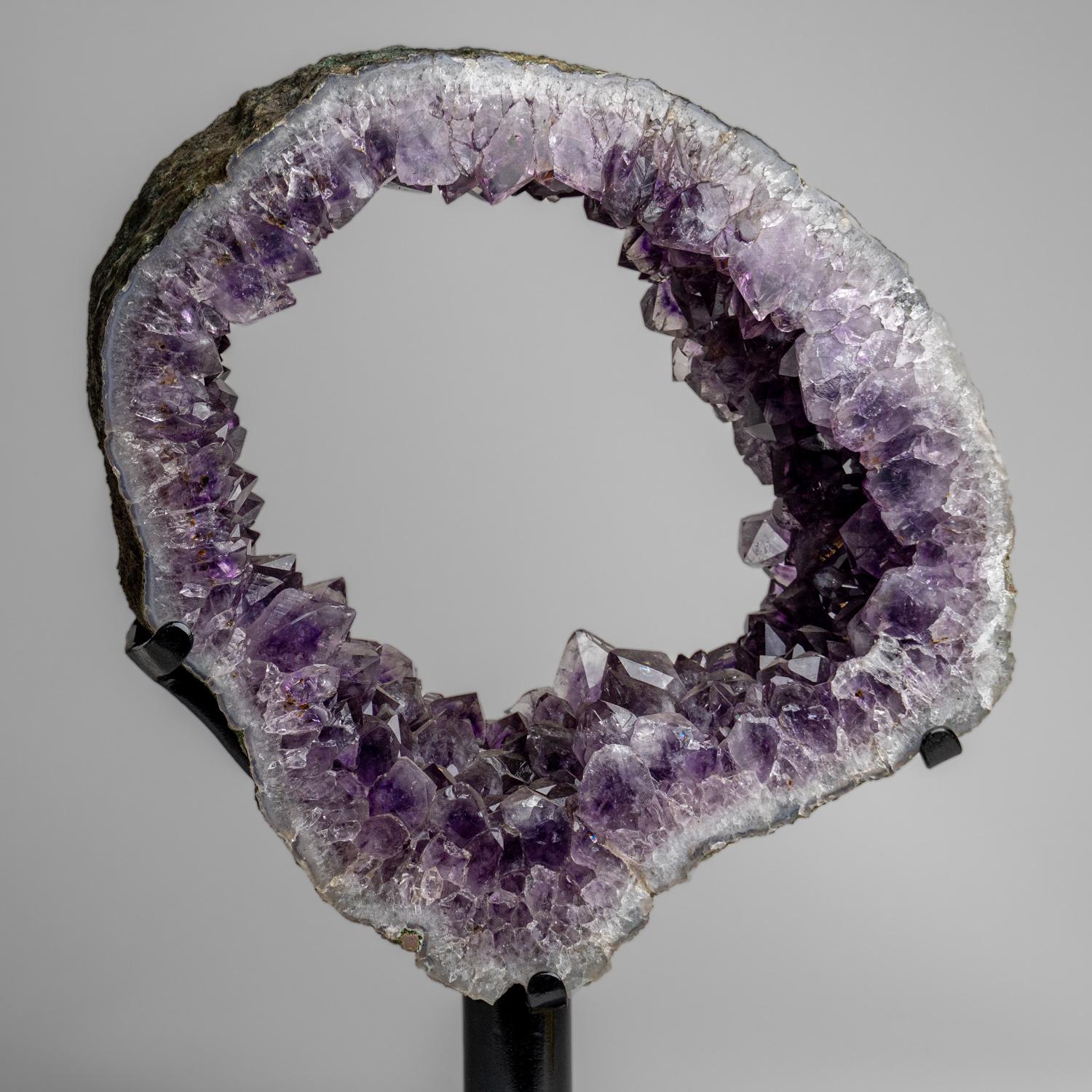 This top museum quality Amethyst Quartz geode slice features naturally formed, lustrous and fully terminated with highly reflective faces and a deep, transparent to translucent hues. This beautiful specimen comes with a metal stand and is perfect