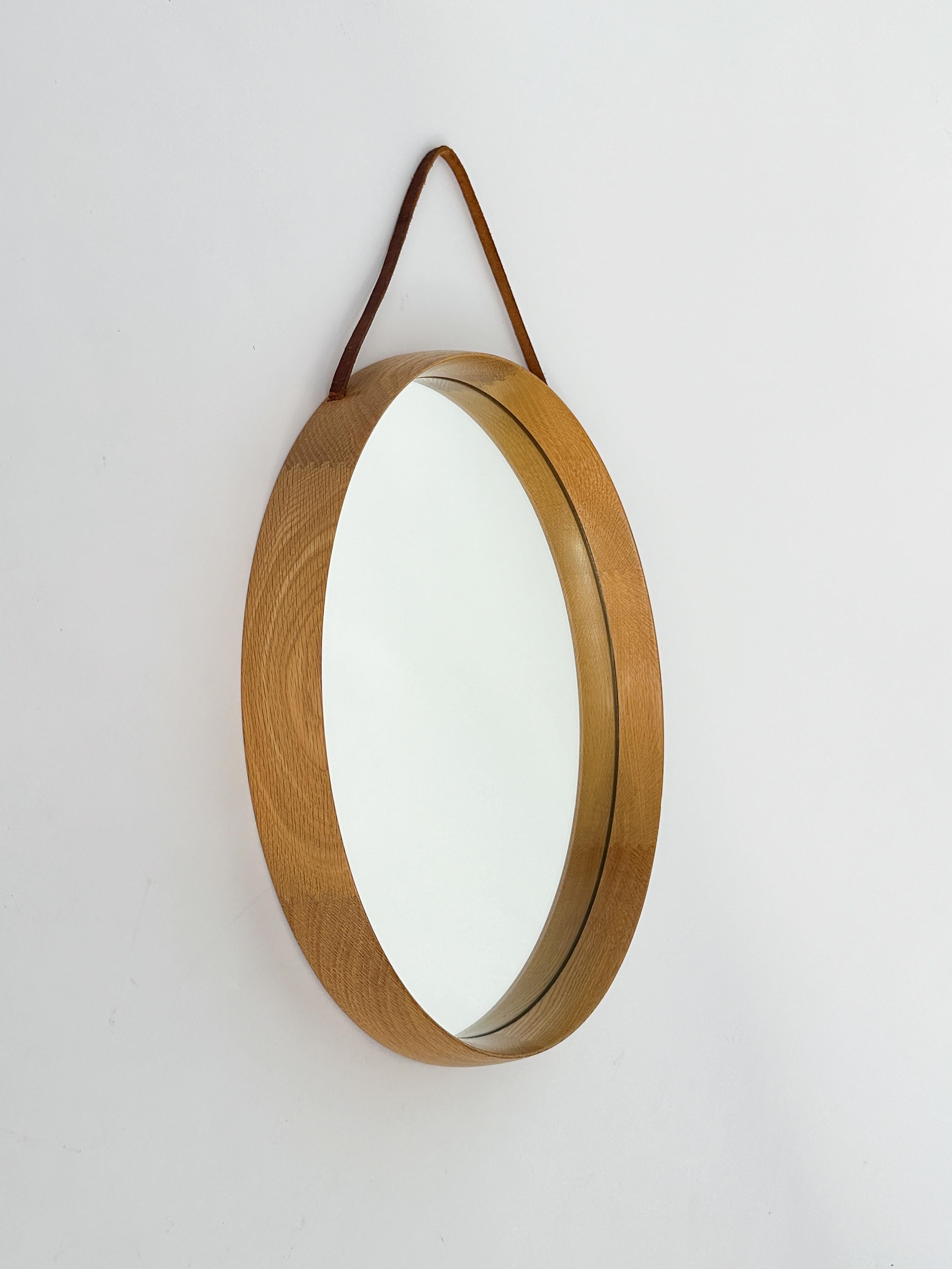 Specchio di Uno & Östen Kristiansson, realizzato dalla loro azienda Luxus a Vittsjö, in Svezia, negli anni '1960.

La struttura è realizzata in rovere massiccio con splendidi dettagli di falegnameria. Cinturino in pelle originale con patina e