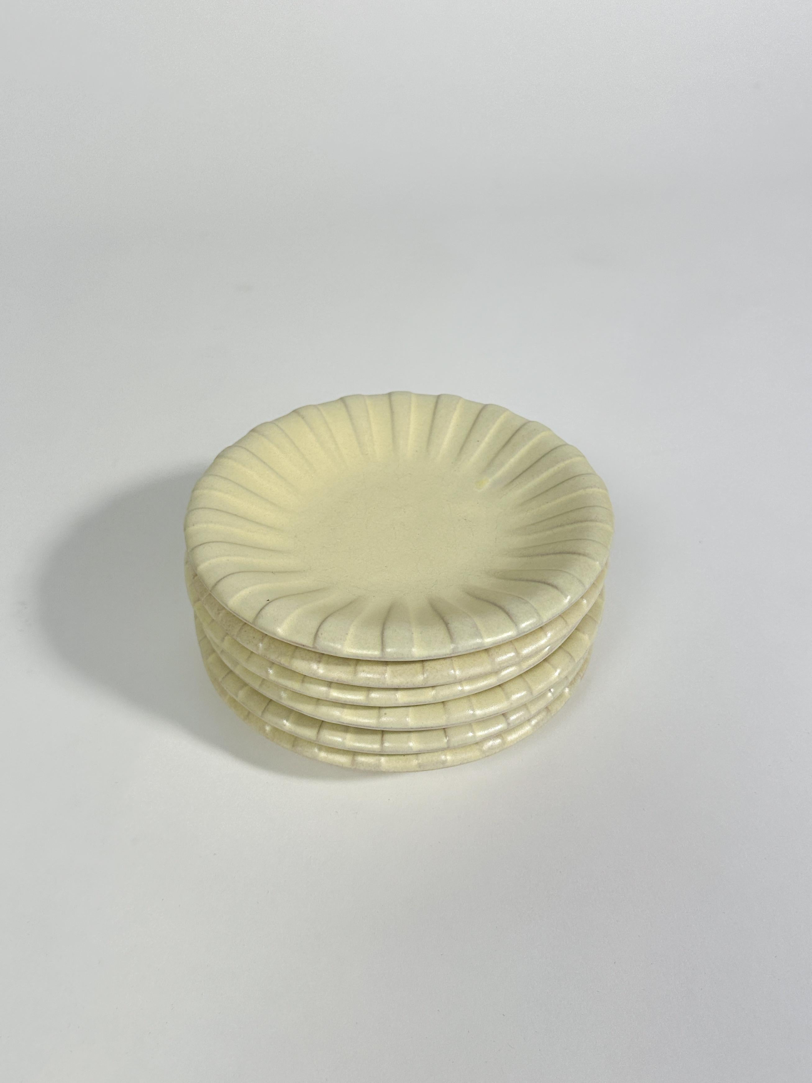 Ensemble de six assiettes de Vicke Lindstrand, faïence artisanale à glaçure jaune beurre, fabriquée pour Upsala Ekeby dans les années 1940 en Suède.

Diamètre : 18 cm

L'une des assiettes présente un éclat de glaçure sous le bord, voir photo. 