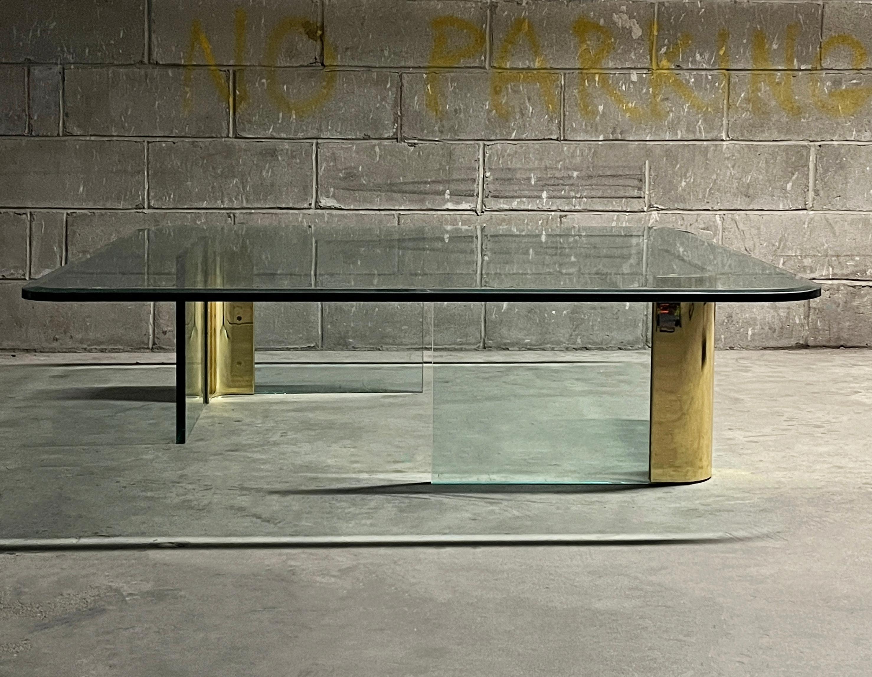 One incredible and collectible brass and green beveled glass mid century modern coffee table by Leon Rosen for Pace Collection, 1970s. The two floating legs with polished curved brass corners support a very heavy 3/4