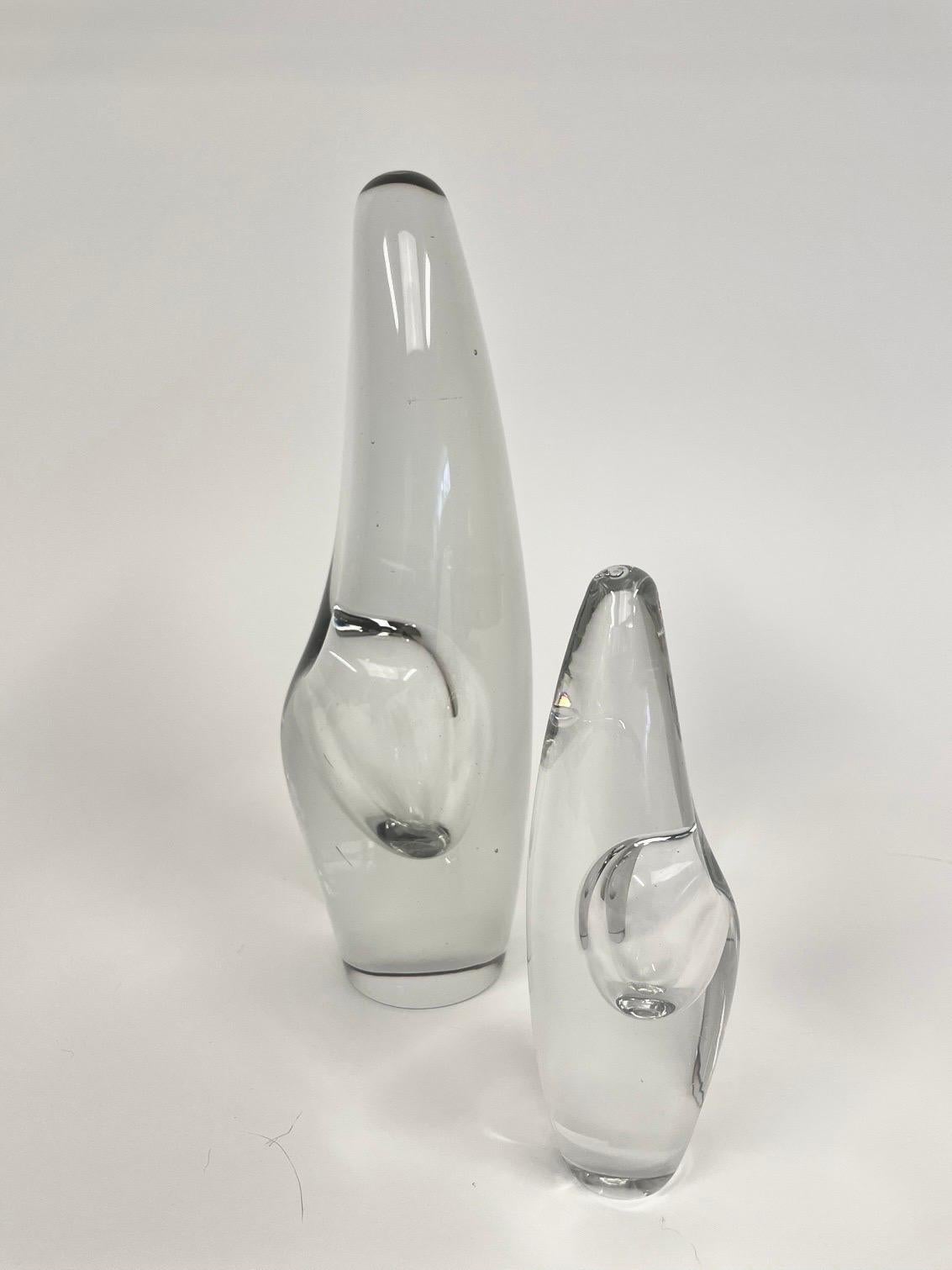 This is the Finnish sculptural pair of vases, model Orckidéa 3568 designed in 1953 in polished crystal glass from Ittala.
They comes with a tower-shaped, tapered shape with a gently rounded top. A steam blown recess in the middle of the sculpture