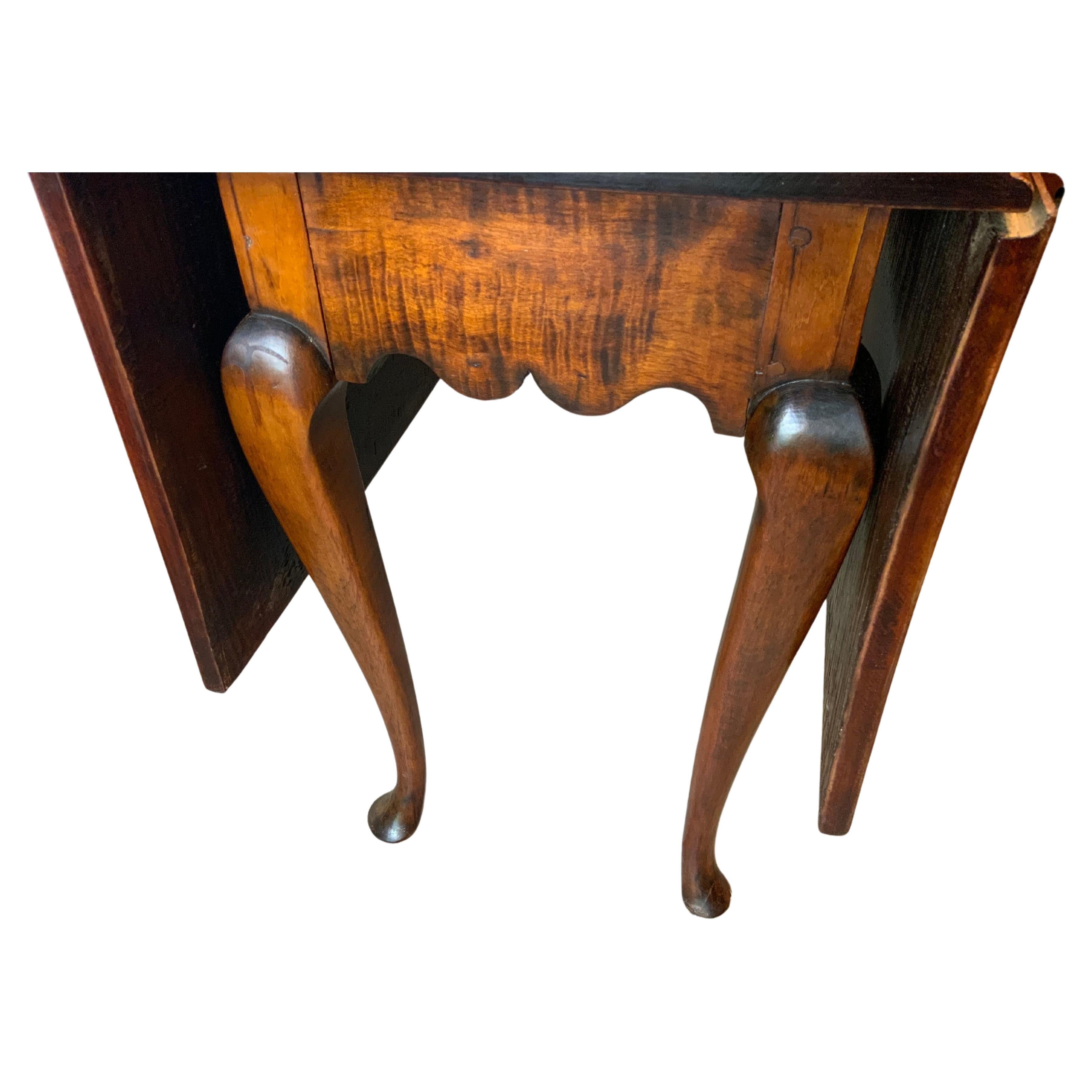 A very attractive early Federal Queen Anne Curly Maple Drop leaf table with a great aged color and patina on an older refinished surface.  Looks to possibly be a very early marriage of an 18th century top and a base of the same age by evidence of