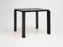 Mesa «Strut» de aluminio negro con un diseño distintivo de las patas hecho a mano