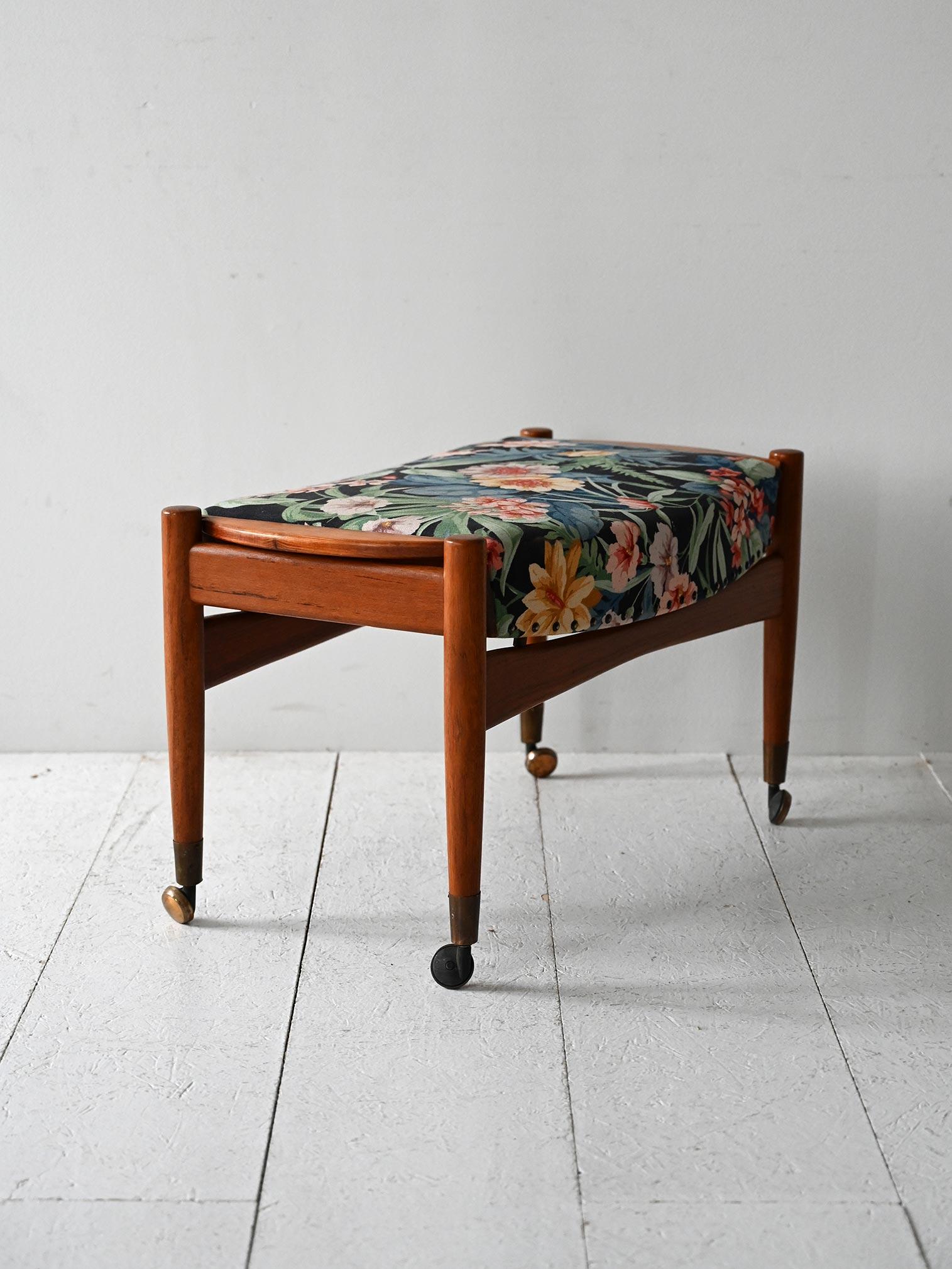 Poggiapiedi vintage con struttura in legno e ruote, rivestito con tessuto floreale originale firmato Josef Frank.

Poggiapiedi scandinavo degli anni ’50 con struttura in legno massello e gambe tornite su rotelle in ottone e bachelite. La seduta