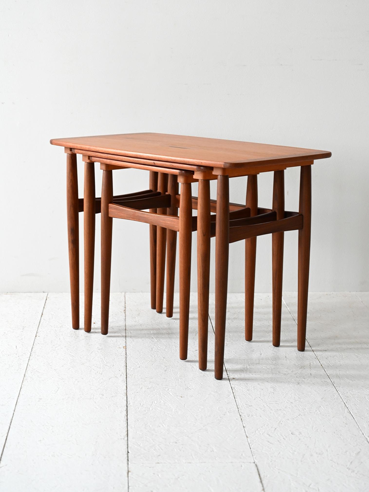 Tre tavolini a incastro in teak degli anni ’60 con gambe tornite affusolate e finiture a leggero contrasto.

Set di tre tavolini scandinavi degli anni ’60 realizzati in teak massello, con piani sagomati e gambe tornite dal profilo affusolato. Le