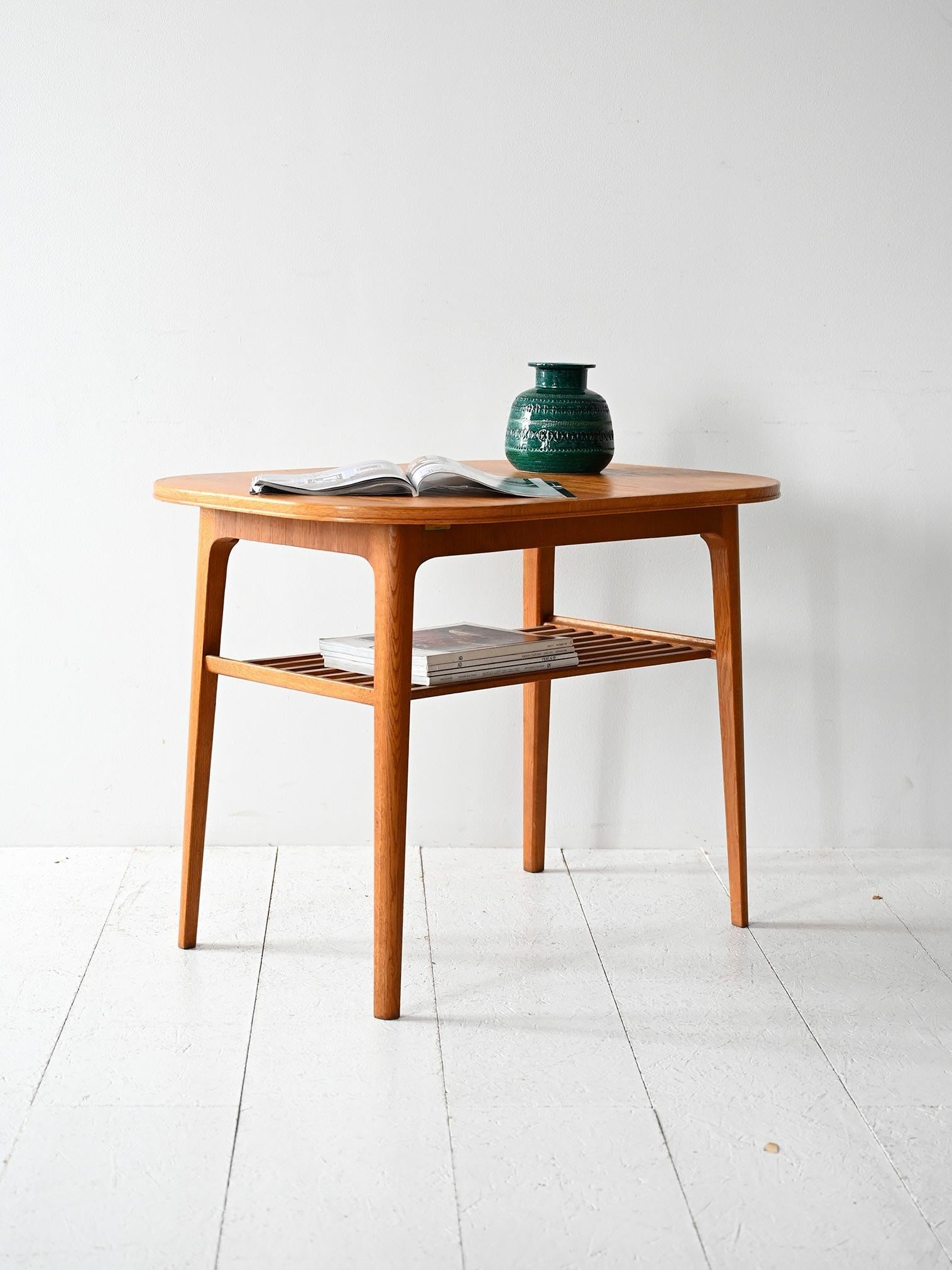 Tavolino vintage in rovere con mensola a listelli e struttura leggera. Prodotto originale con etichetta Kägers Industrier AB.

Tavolino scandinavo da salotto degli anni 60 realizzato in rovere massello. Piano superiore stondato e struttura leggera