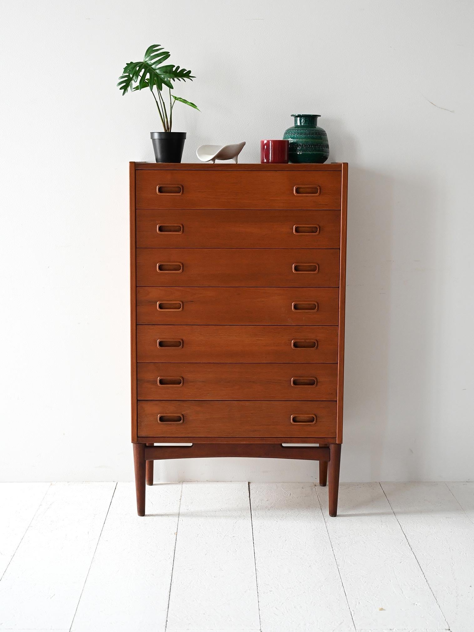 Cassettiera vintage a sette cassetti con gambe tornite, maniglie ovali e barre strutturali in legno curvato.

Cassettiera settimanale danese degli anni 60, realizzata in teak massello con finitura calda e uniforme. Sette cassetti con doppie maniglie