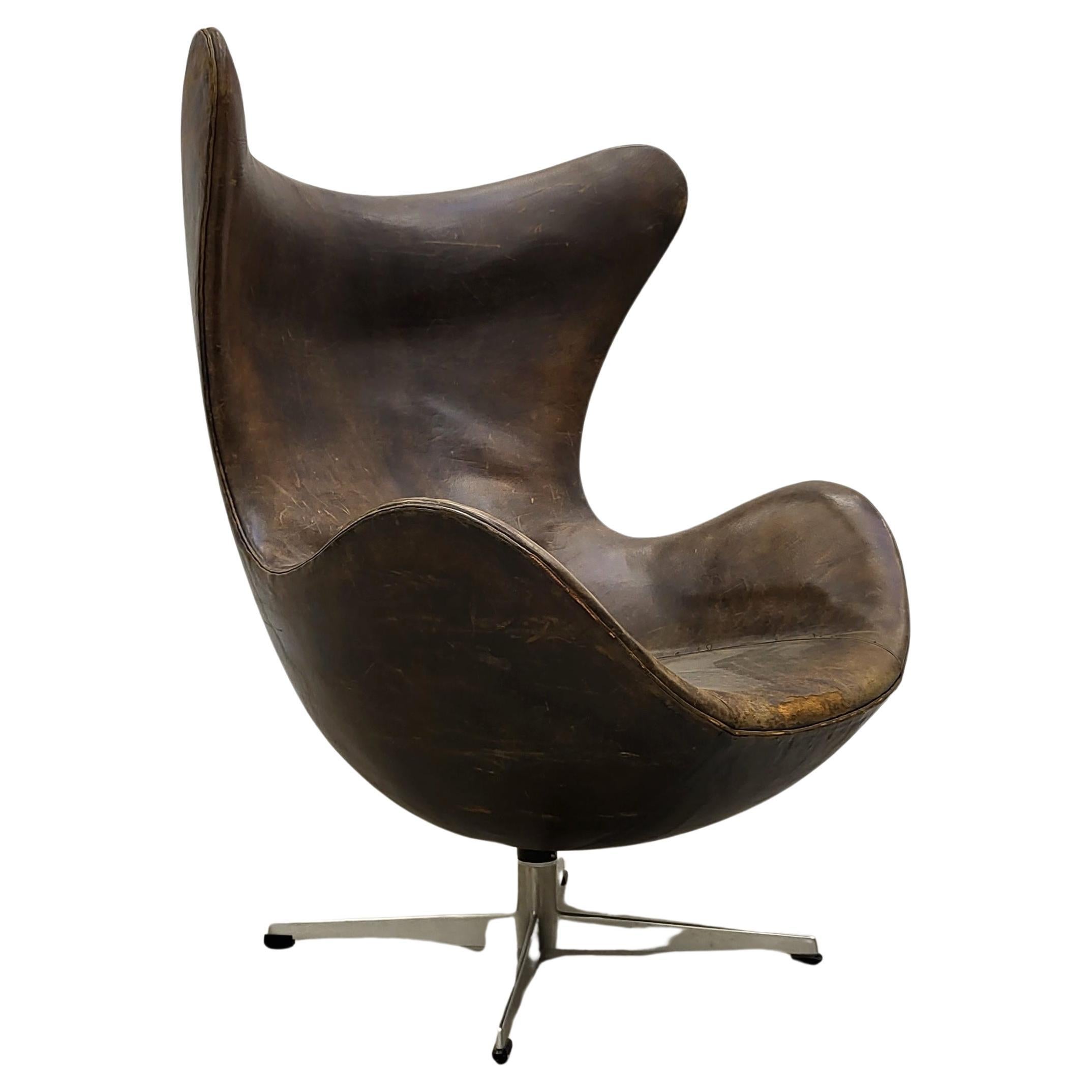 Cette très rare chaise à œuf de première édition a été conçue dans les années 50 par Arne Jacobsen pour l'hôtel SAS de Copenhague et produite par Fritz Hansen vers 1958/1959. 

La chaise est recouverte d'un magnifique cuir brun noir qui présente une