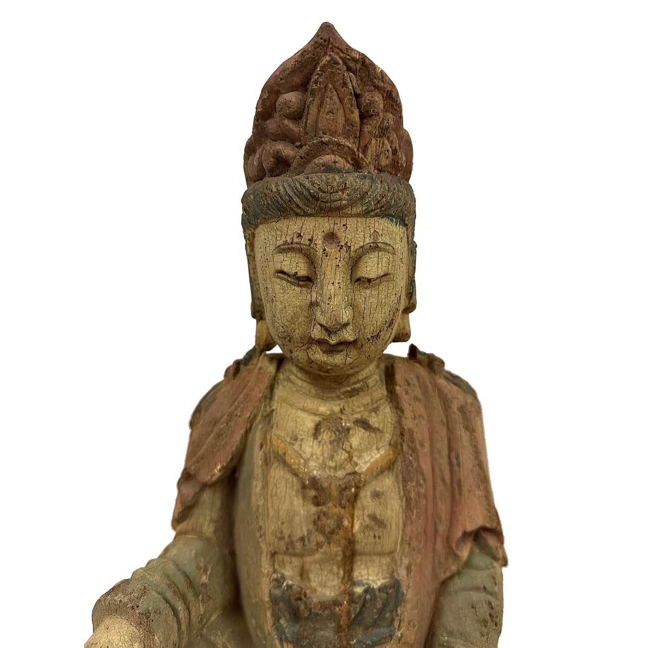 L'image montre une statue de Guanyin, également connue sous le nom d'Avalokiteshvara, un bodhisattva de la compassion largement vénéré dans le bouddhisme. Elle a été réalisée en bois de camphrier, qui a une longue histoire dans la sculpture chinoise