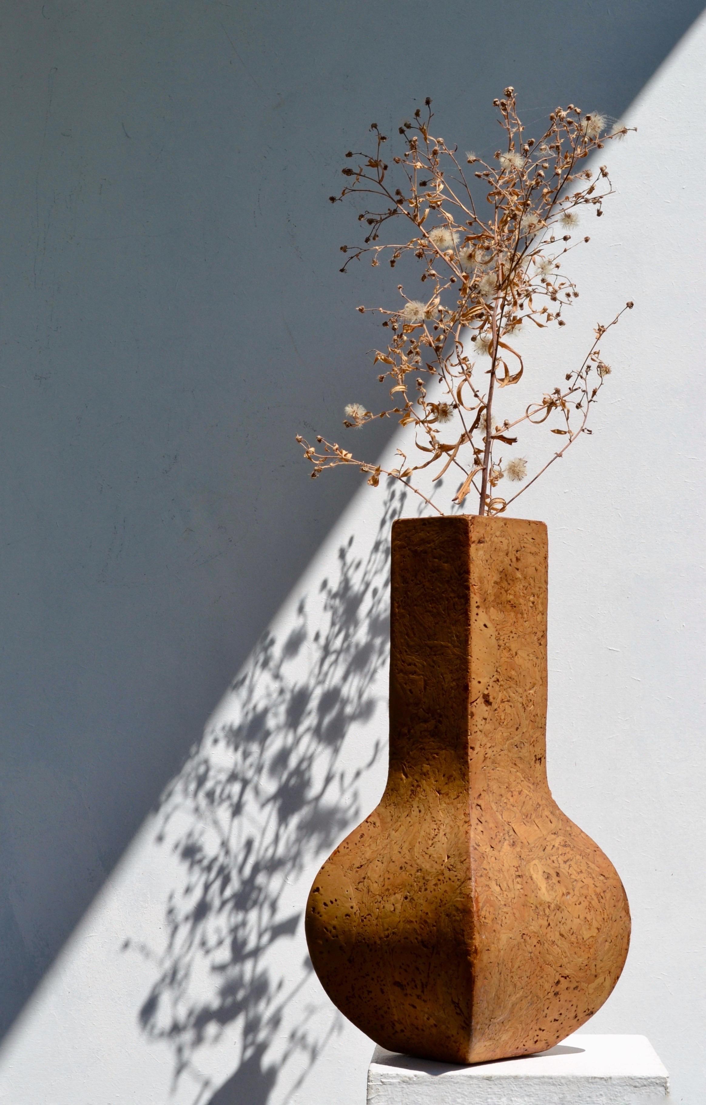 Un raro e scultoreo vaso in sughero massiccio proveniente dalla Francia degli anni '70, che esemplifica il fascino dell'epoca per i materiali naturali e il modernismo organico. Interamente realizzato in sughero, questo pezzo unisce la funzionalità
