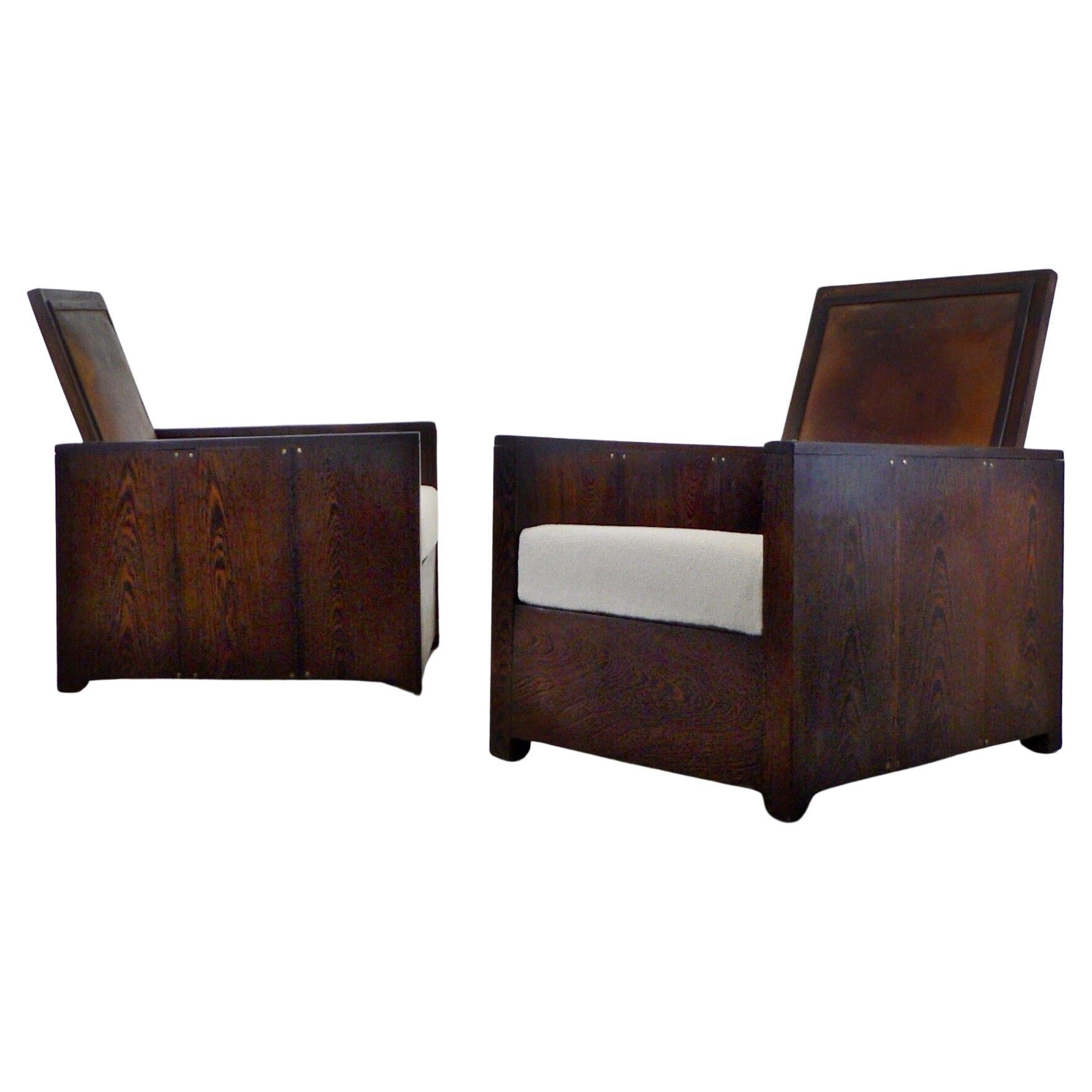 A rare and exquisite pair of French Modernist/Art Deco club lounge chairs, crafted by hand around the 1920s, stands out for their solid wenge wood construction. These chairs, potentially one of a kind, present a distinctive fusion of minimalist