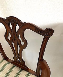 Sillón de caoba tallado a mano con gran elegancia, de estilo Chippendale y con asiento firme.