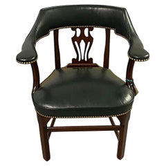 Poltrona in mogano rivestita in pelle verde cacciatore con rifiniture in ottone a chiodini