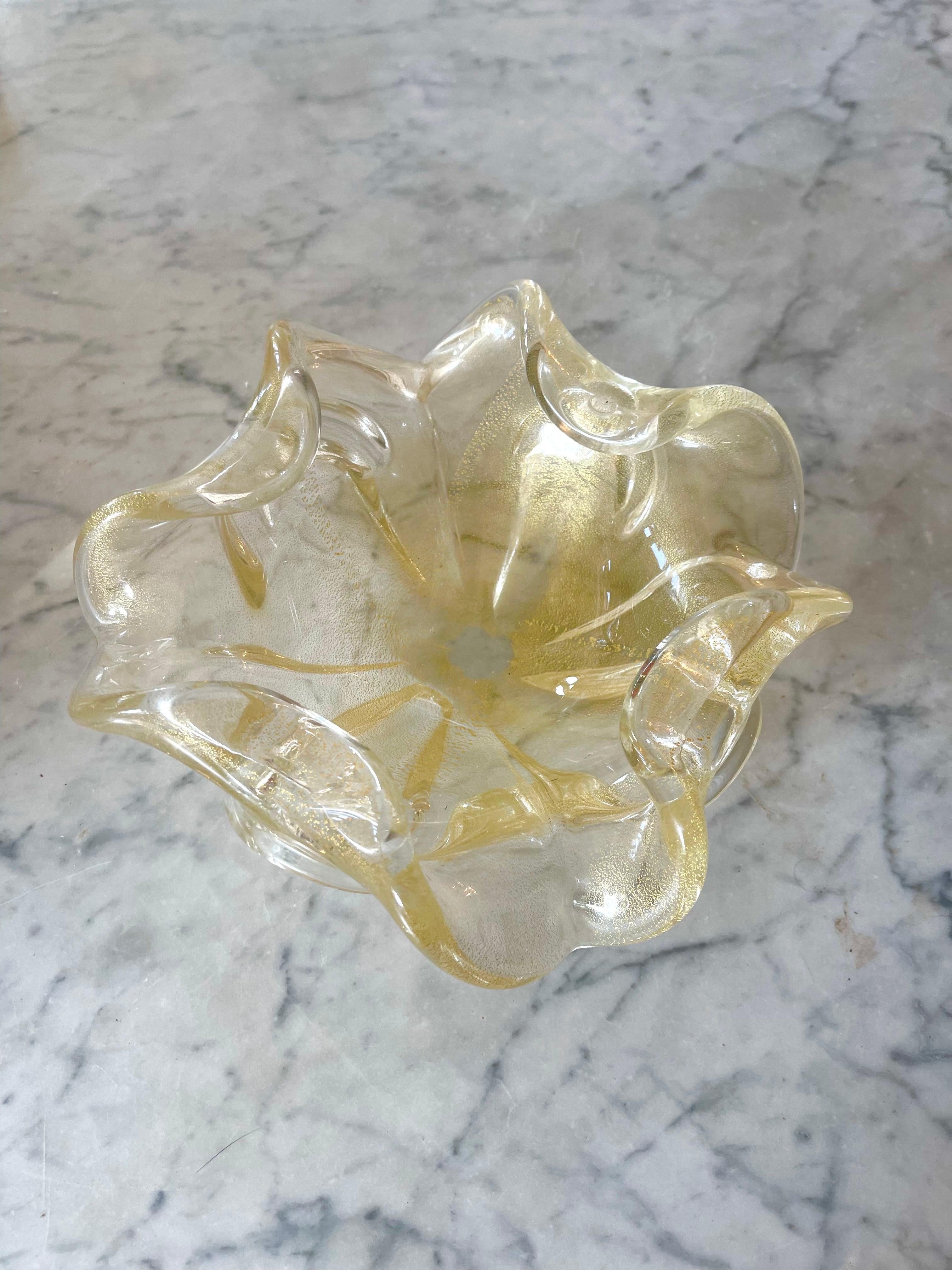 Una impresionante obra de arte hecha a mano con el mejor cristal soplado de Murano, con incrustaciones de preciosas láminas de oro de 24 quilates. Su transparencia cristalina y la elegancia del pan de oro confieren al centro de mesa un aura de