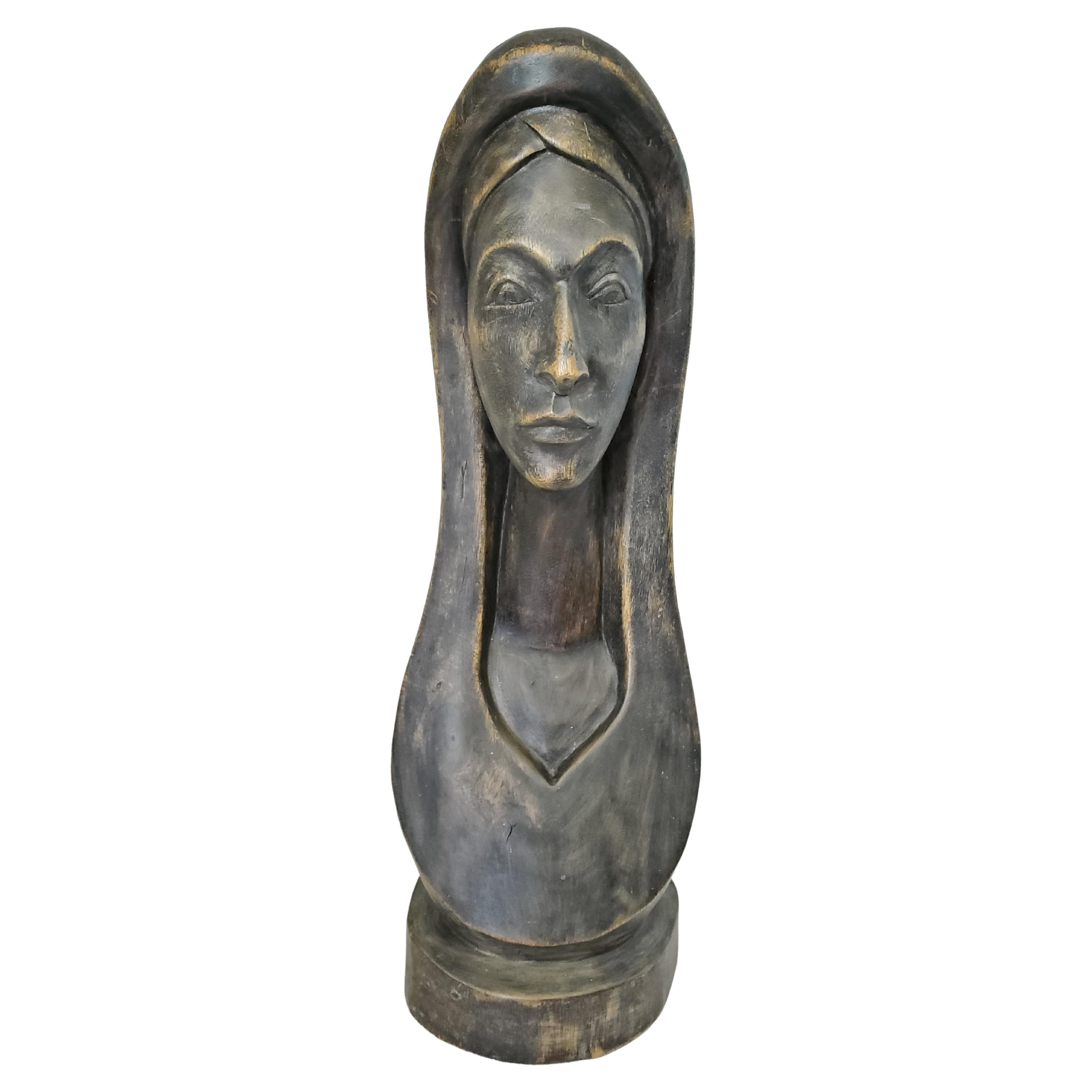 This bronzed wood sculpture or bust is beautifully carved in a minimalist style that evokes a sense of serenity. Interestingly, this wooden sculpture comes from Vaudreuil-Dorion, Quebec -- formerly a 17th century French Catholic settlement in what