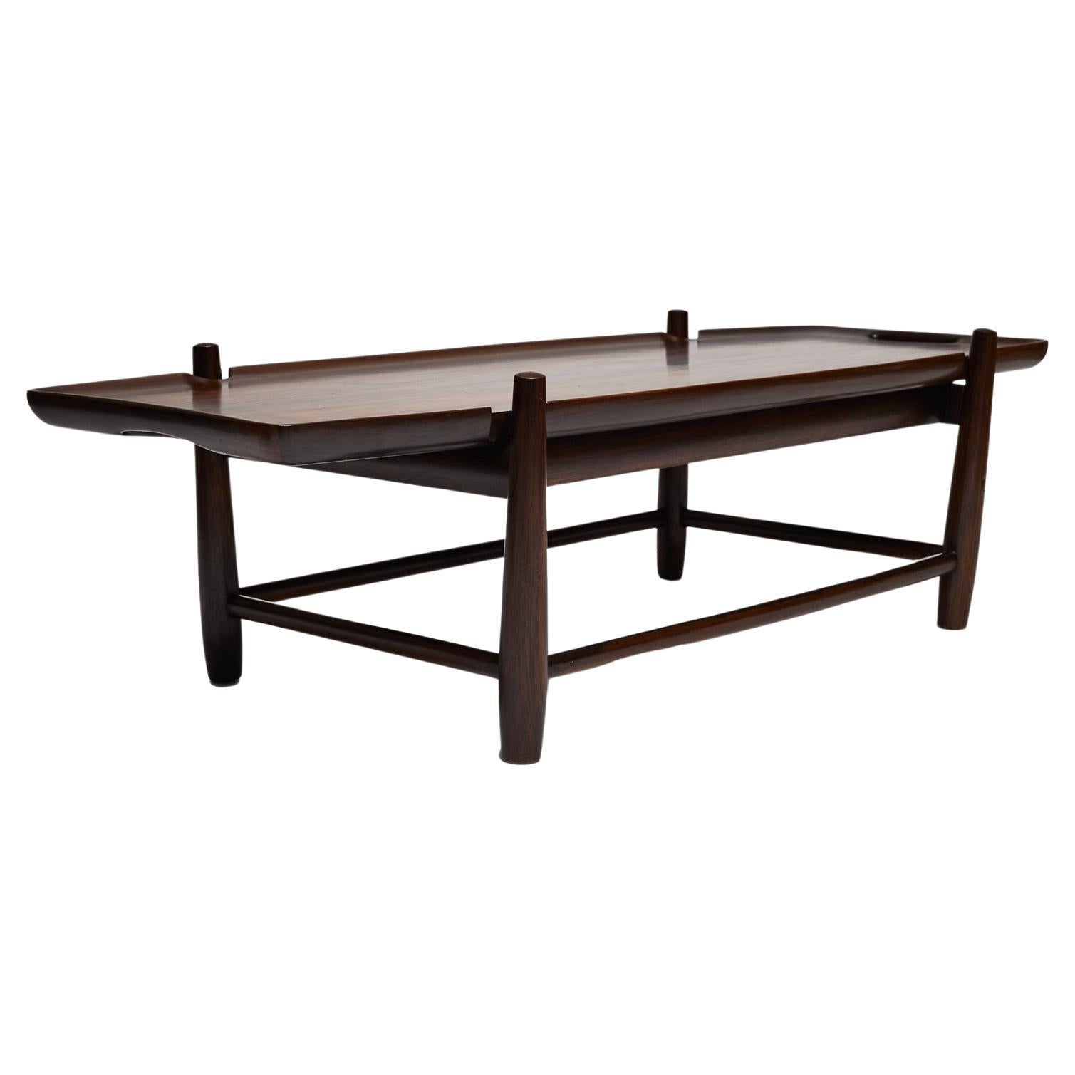 Available today, the “Arimelo” Coffee table has handles in Brazilian rosewood (called Jacaranda) and a solid jacaranda frame. The hardwood has been refinished highlighting the wood veins and age of the piece. This piece has a beautiful design